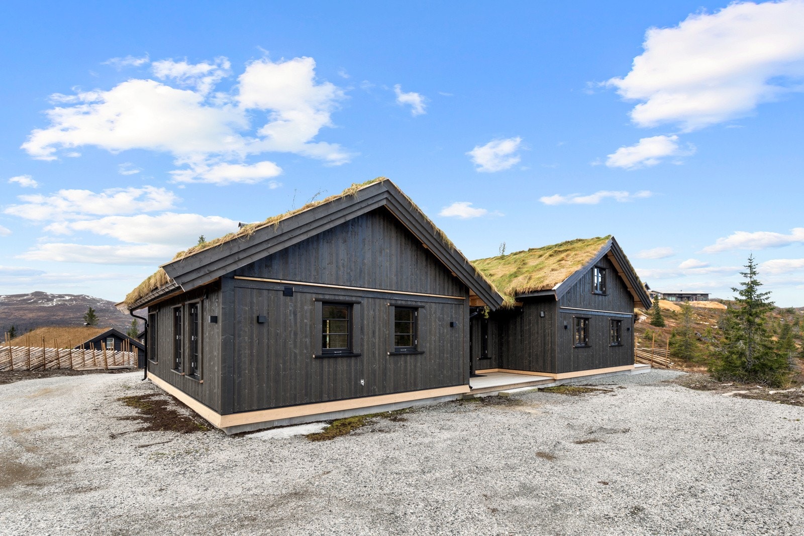 Stor gruslagt gårdsplass med plass til flere biler. Montert elbillader. Galleribilde