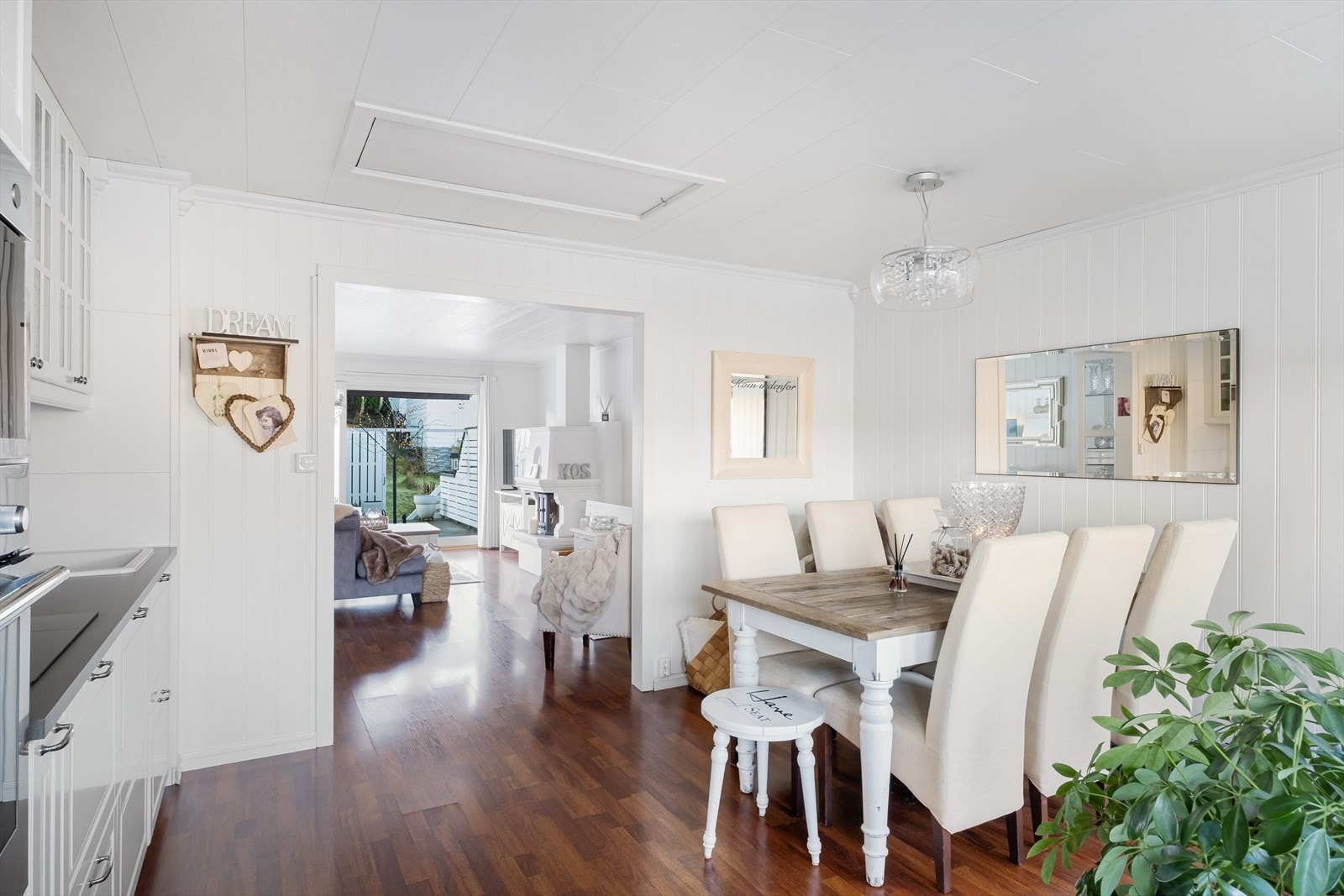 Innbydende spiseplass med gjennomgående stil, der naturlig lys og varme materialer skaper en harmonisk forbindelse mellom kjøkken og stue Galleribilde