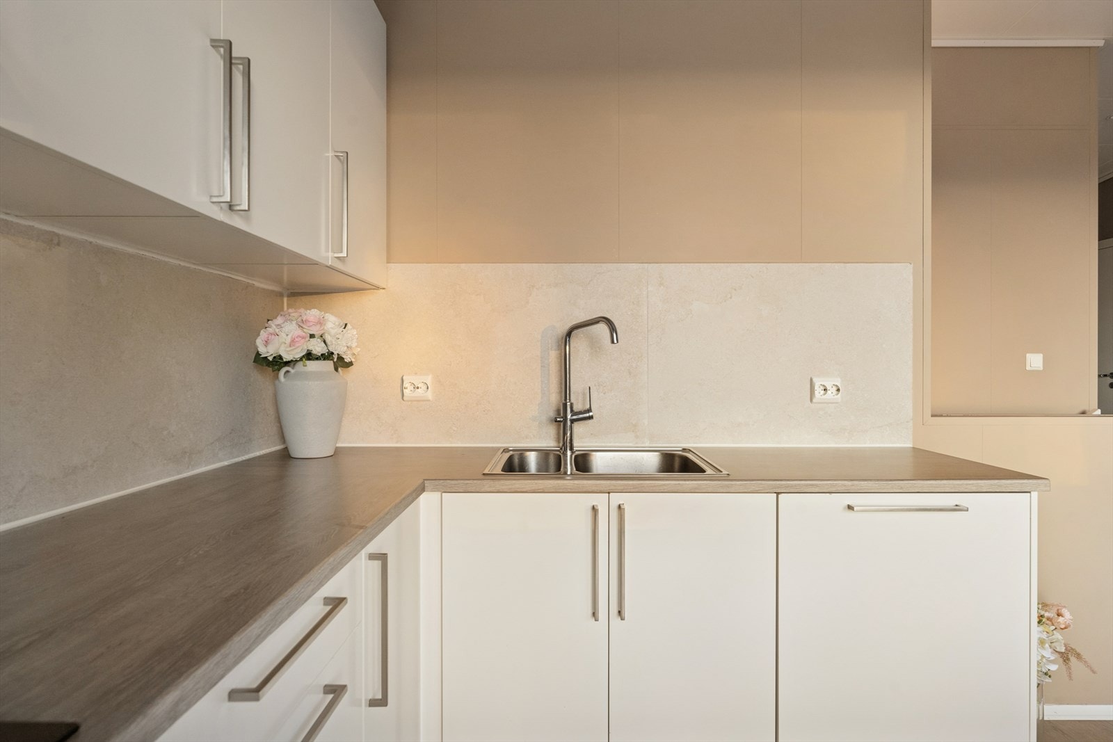 Over benken er det fliser i en dus beigefarge som både harmonerer med interiøret og beskytter mot vannsprut og søl fra matlaging Galleribilde