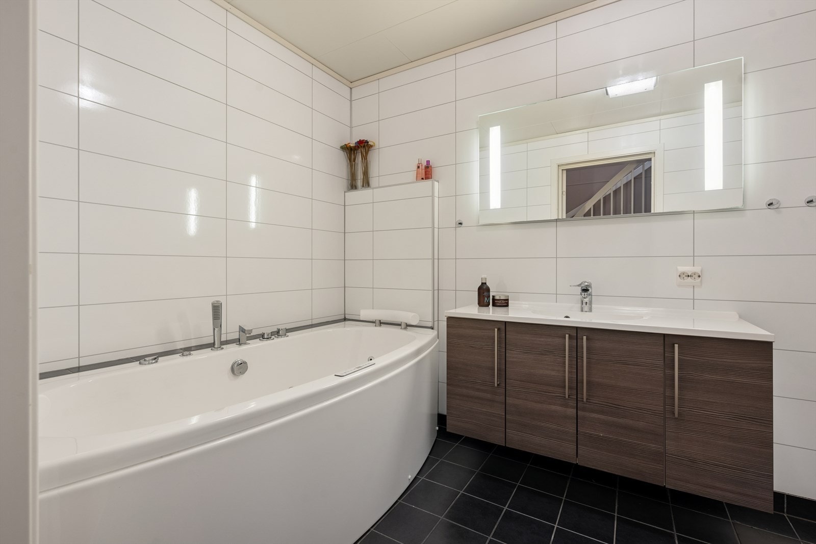 Sanitærutstyr bestående av lekkert badekar med lys, servant, dusjgarnityr og veggmontert toalett Galleribilde