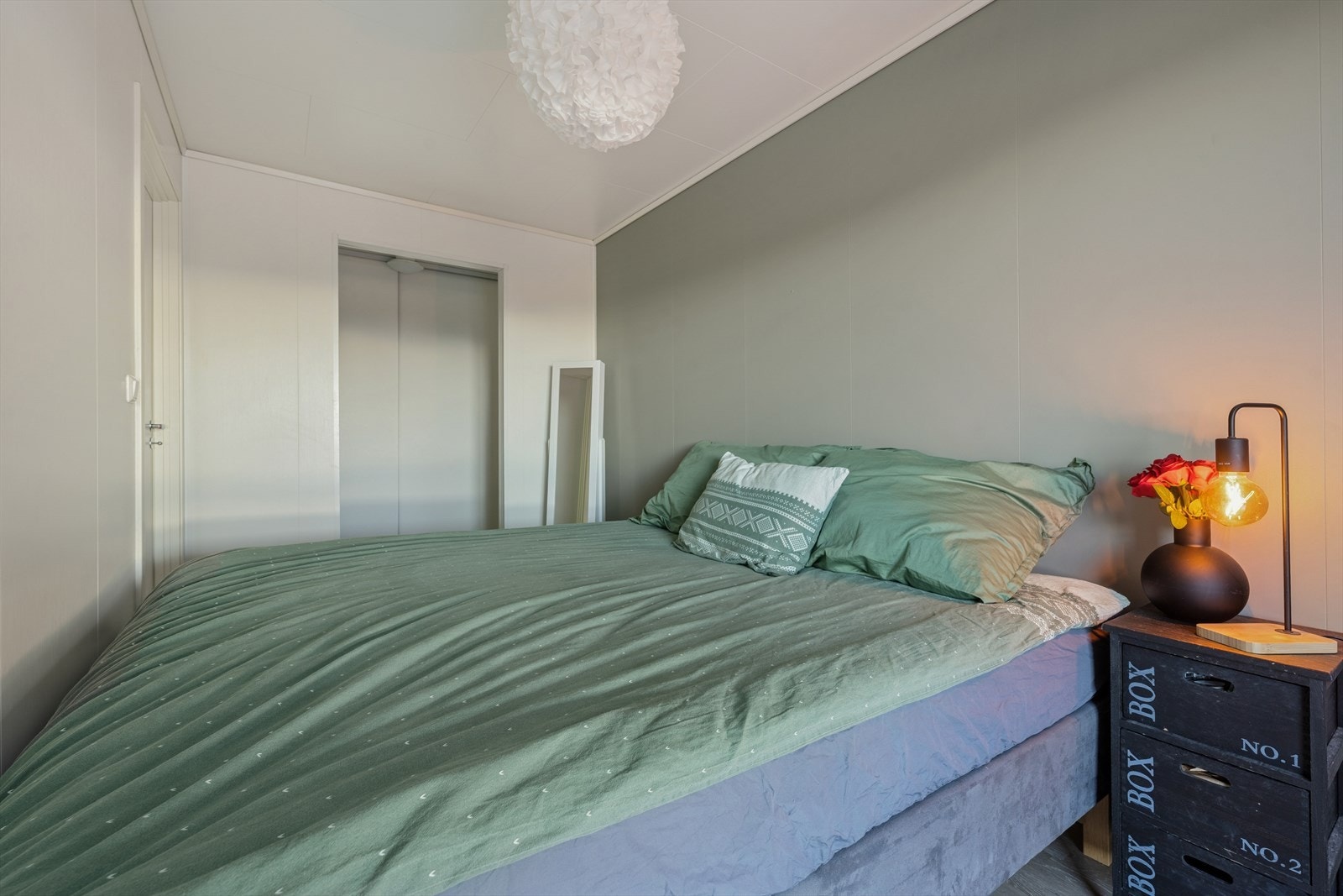 Hovedsoverommet har en praktisk garderobenisje innredet med skap med glatte, stilrene fronter Galleribilde