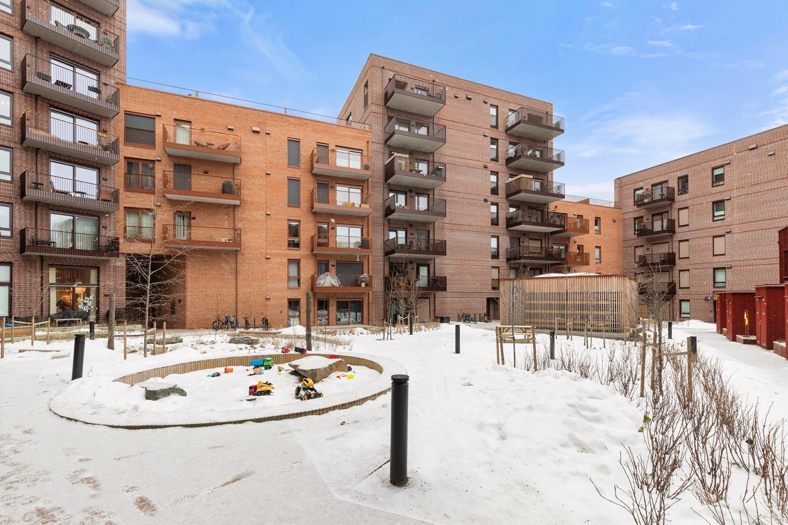 Fellesområde som er pent opparbeidet med lekeområder og sitteplasser. Galleribilde