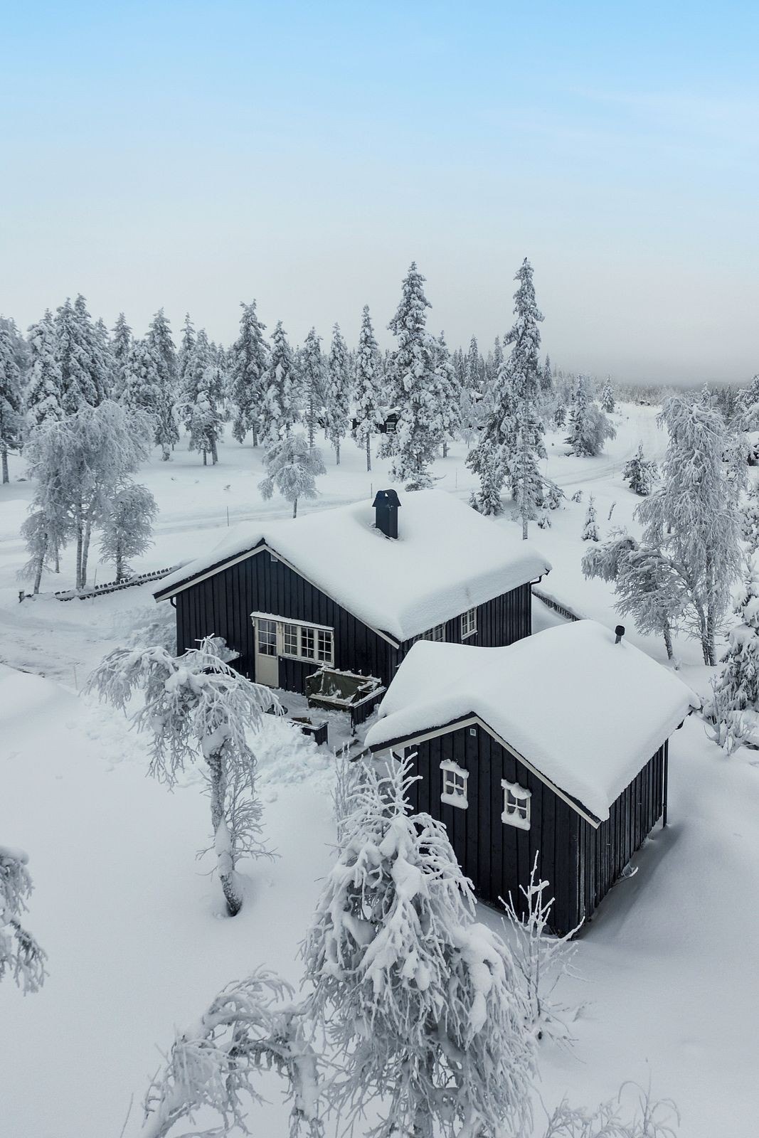 Hytta med tilhørende anneks som ligger fint til i terrenget, omkranset av snøtunge trær. Galleribilde