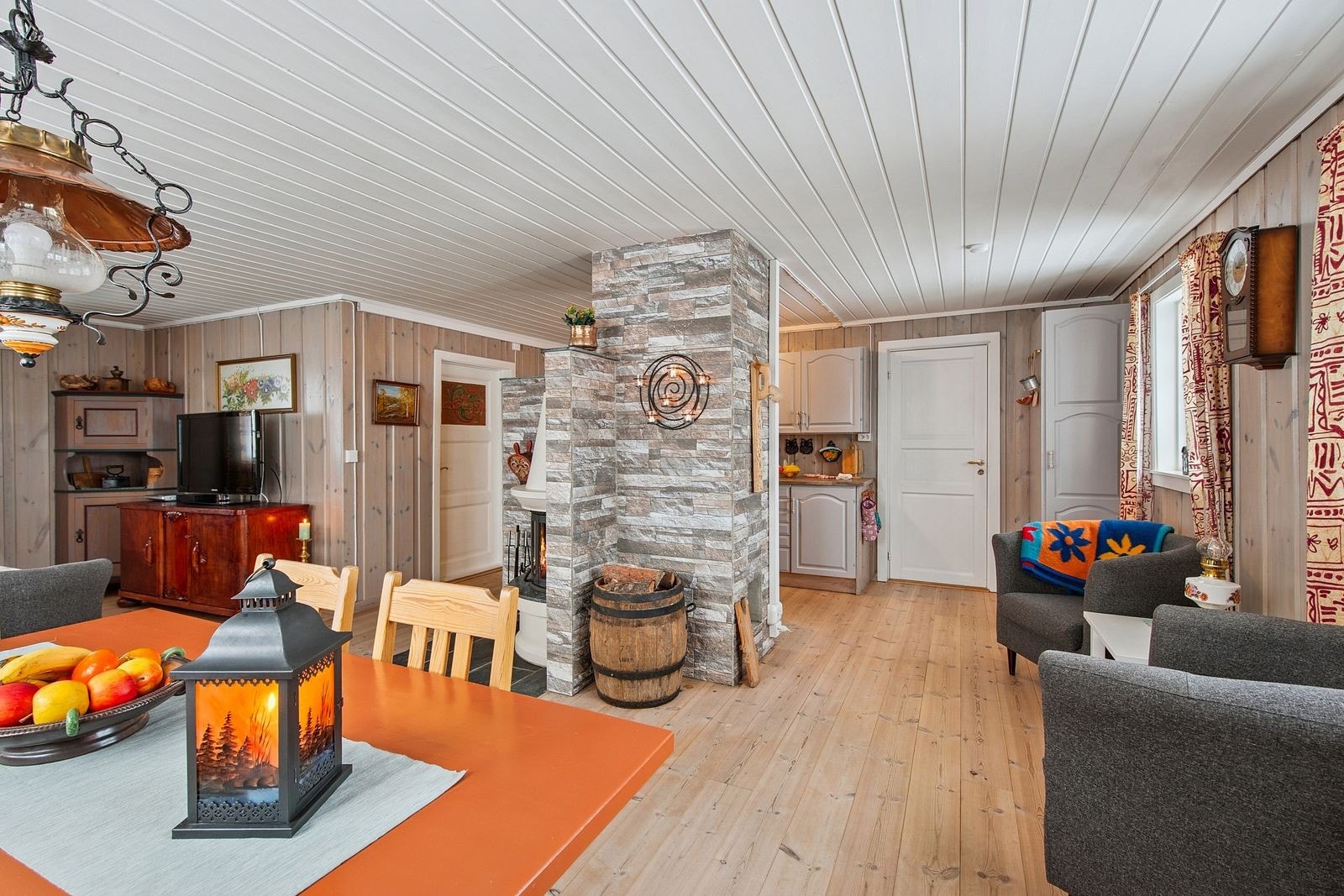 Peisen fungerer som en naturlig romdeler mellom stue og kjøkken. Galleribilde