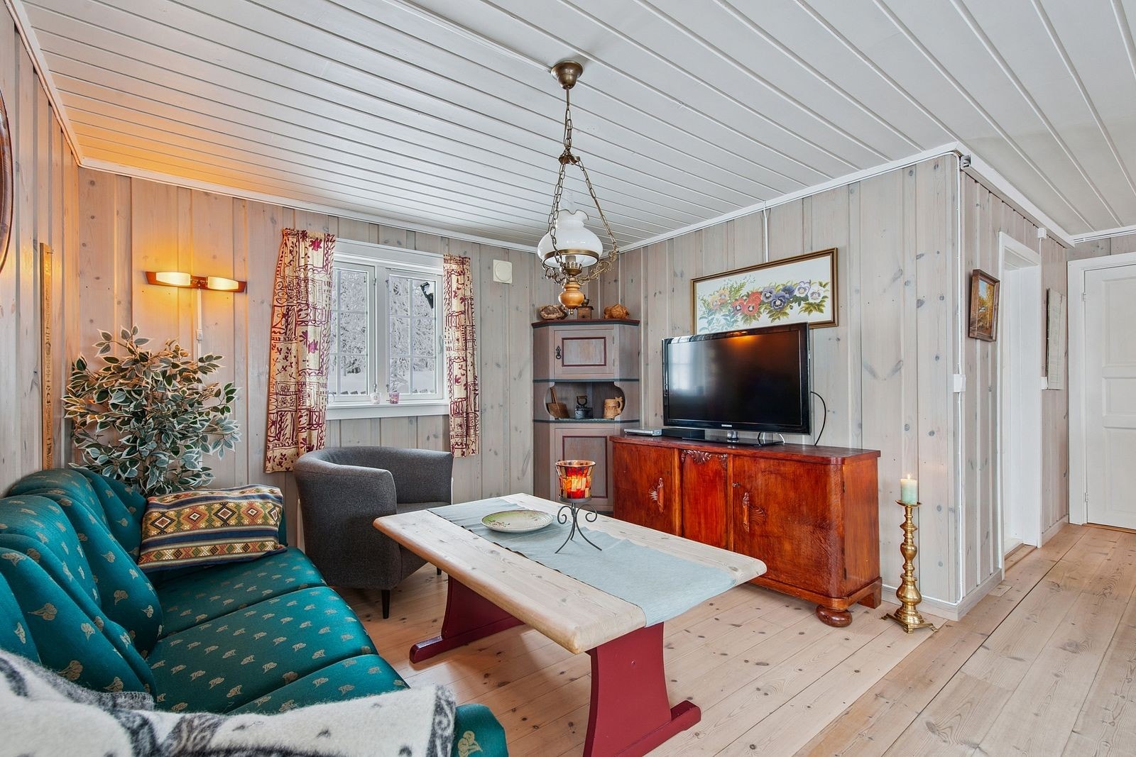 Sofakroken med TV. På byggetegninger er det her tenkt et tredje soverom. Galleribilde