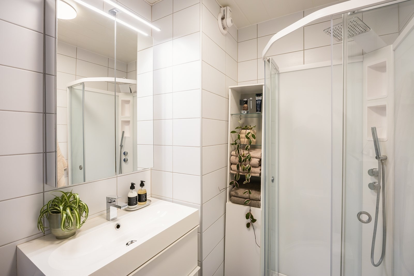 Flislagt bad med dusjkabinett, vegghengt toalett og innredning med servant. Galleribilde