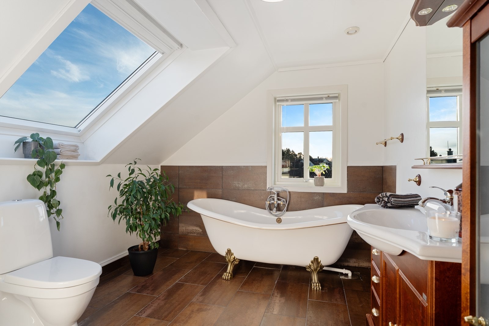 Stort bad på loftet som er innredet med gulvstående toalett (nytt i 2024), badekar og baderomsinnredning med god oppbevaringsplass Galleribilde