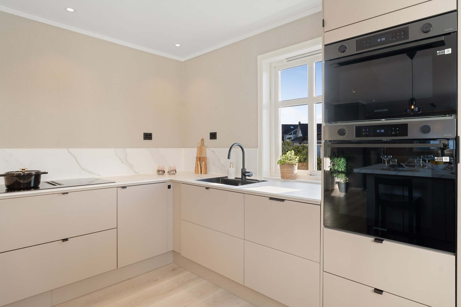 Kjøkkenet har slette fronter og laminat benkeplate - alle hvitevarene er integrert for et stilrent og moderne uttrykk Galleribilde