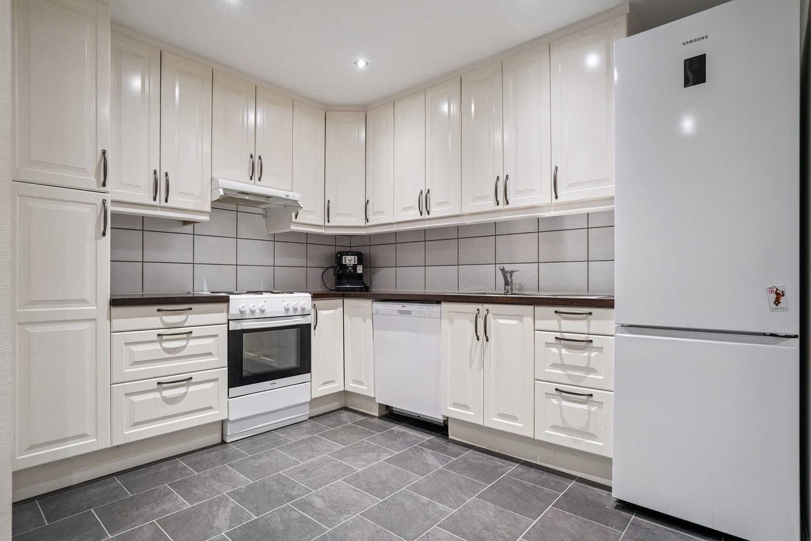 Lys kjøkkeninnredning med laminat benkeplate. Galleribilde