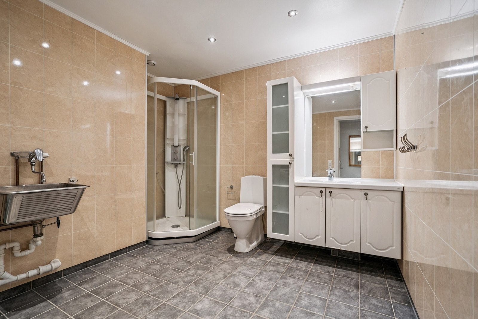 Badet er utstyrt med dusjkabinett, toalett, varmtvannsbereder, opplegg for vaskemaskin, vask og baderomsinnredning. Galleribilde