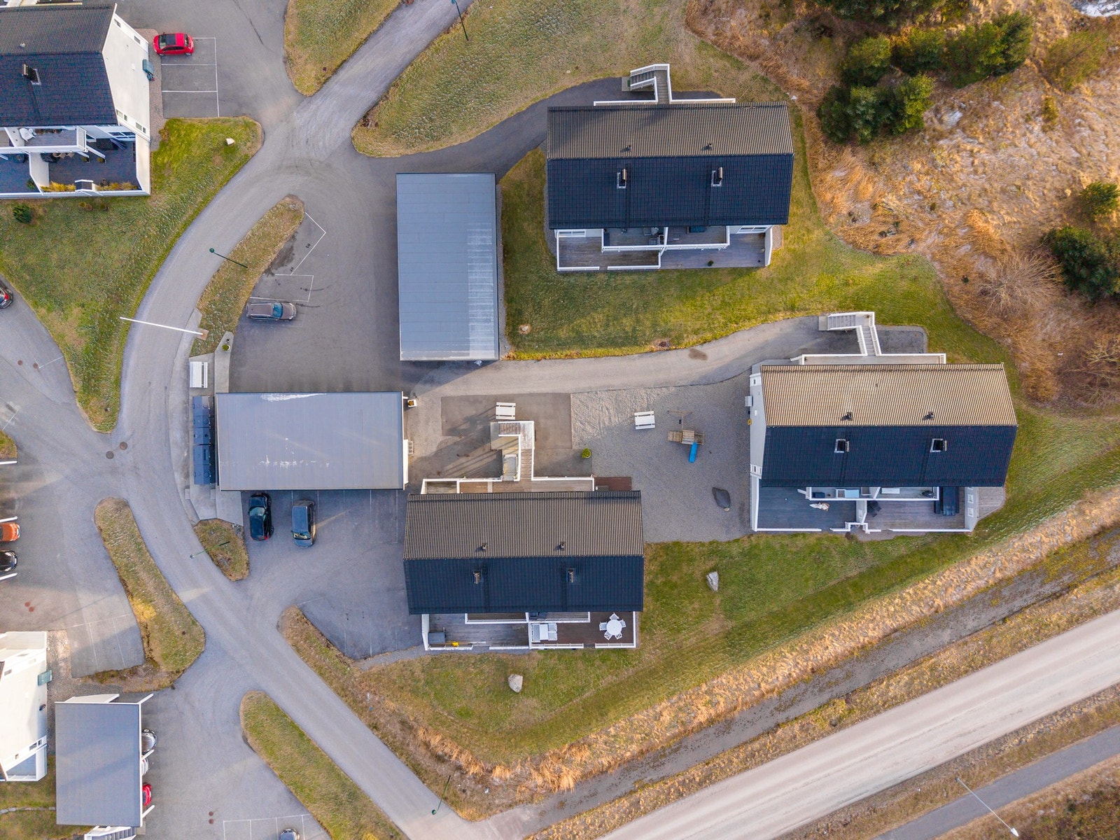 Deler av sameiet sett fra fugleperspektiv. Både carport og gjesteparkering ligger få meter unna inngangsdøren. Galleribilde