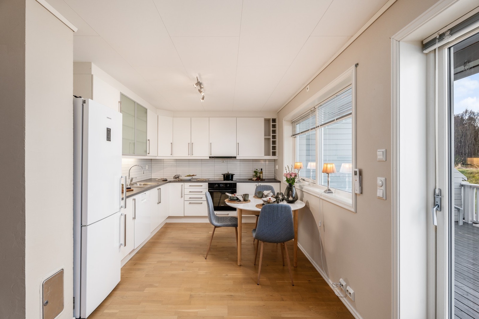 Fra stue/kjøkken har man utgang til terrasse med vestvendt orientering. Til venstre skimter du pipe, den er klar i tilfelle du vil montere inn vedovn. Galleribilde