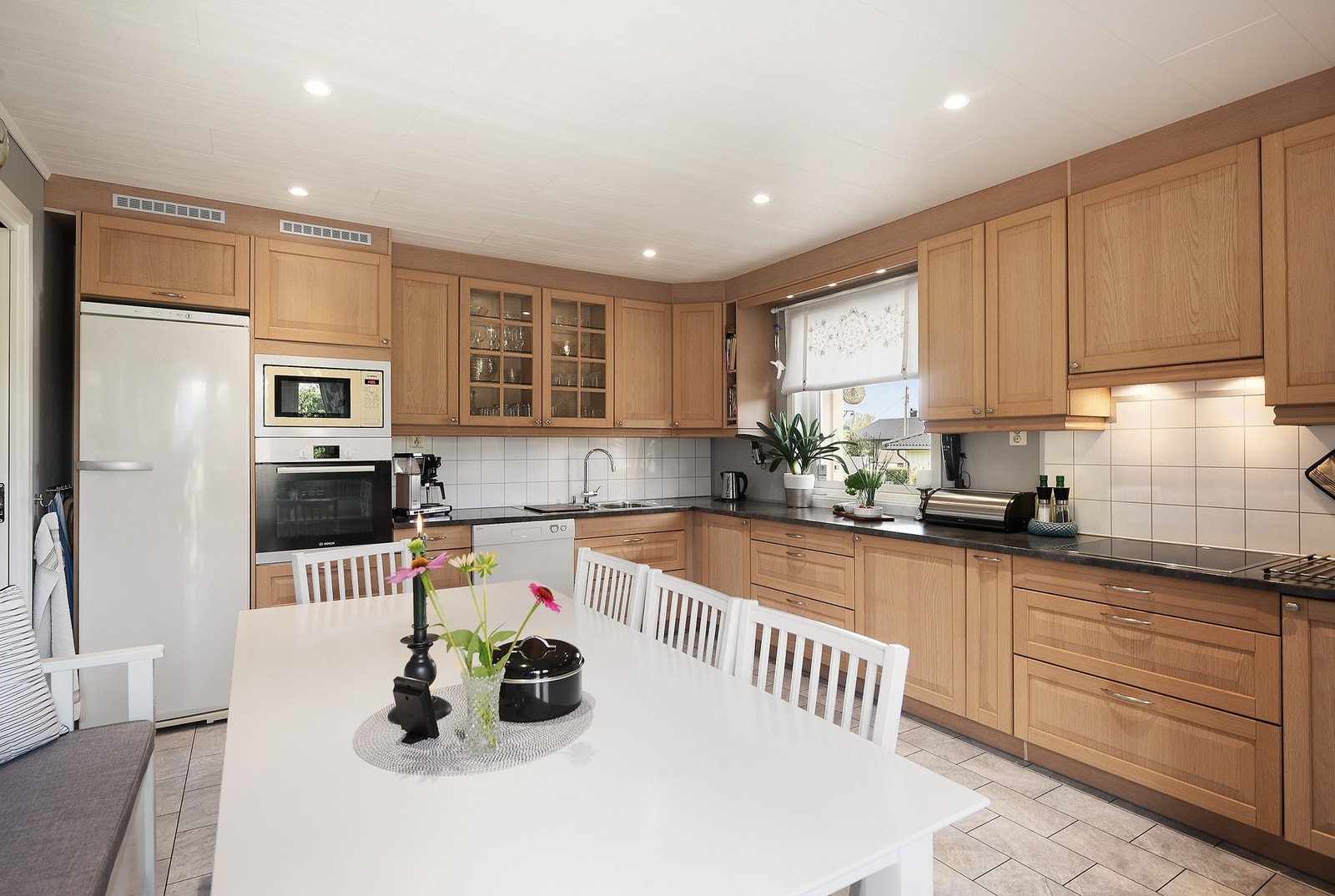 Pent kjøkken med god benkeplass og spisebord Galleribilde