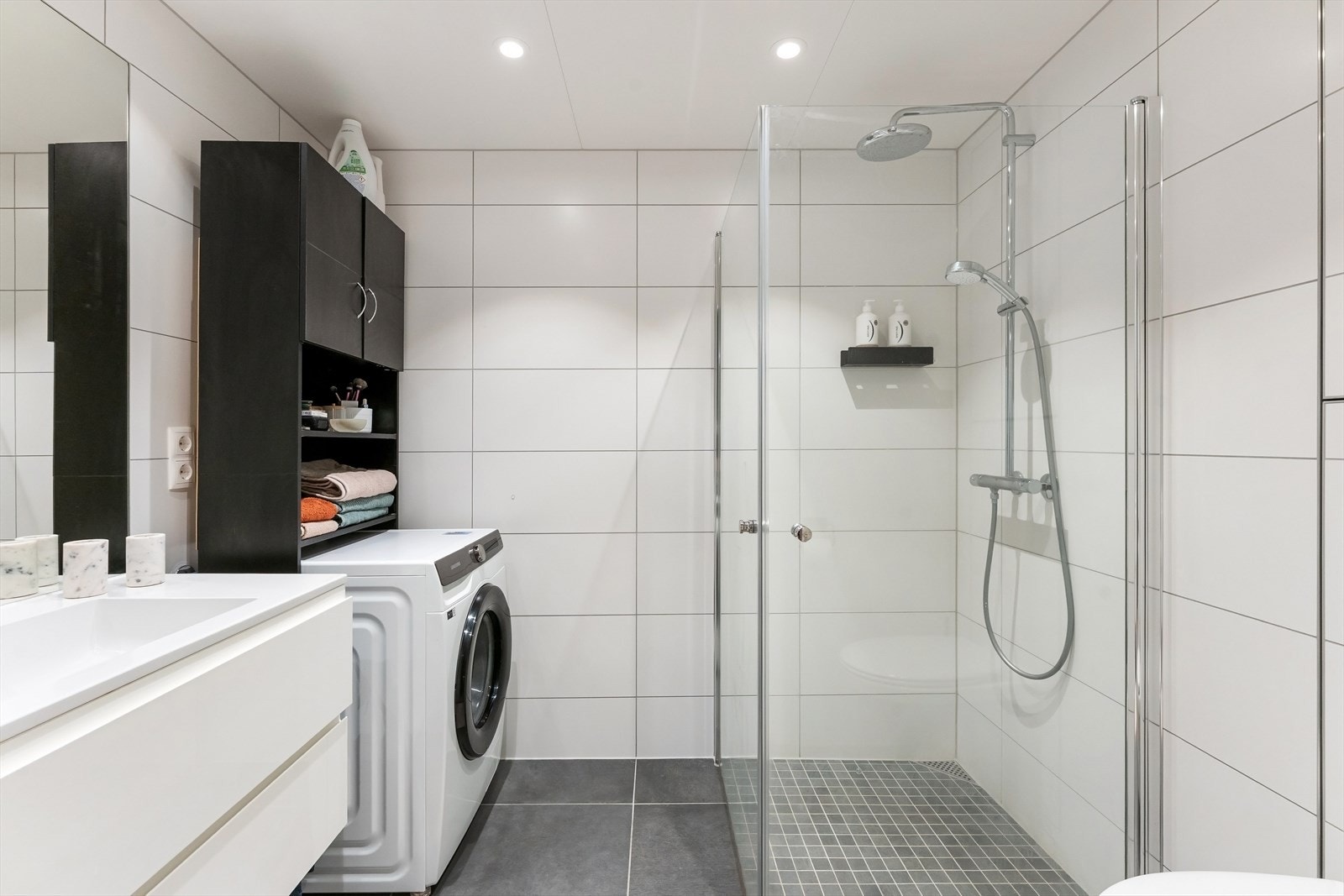 Dusjhjørne med svingbare dører og opplegg for vaskemaskin. Galleribilde