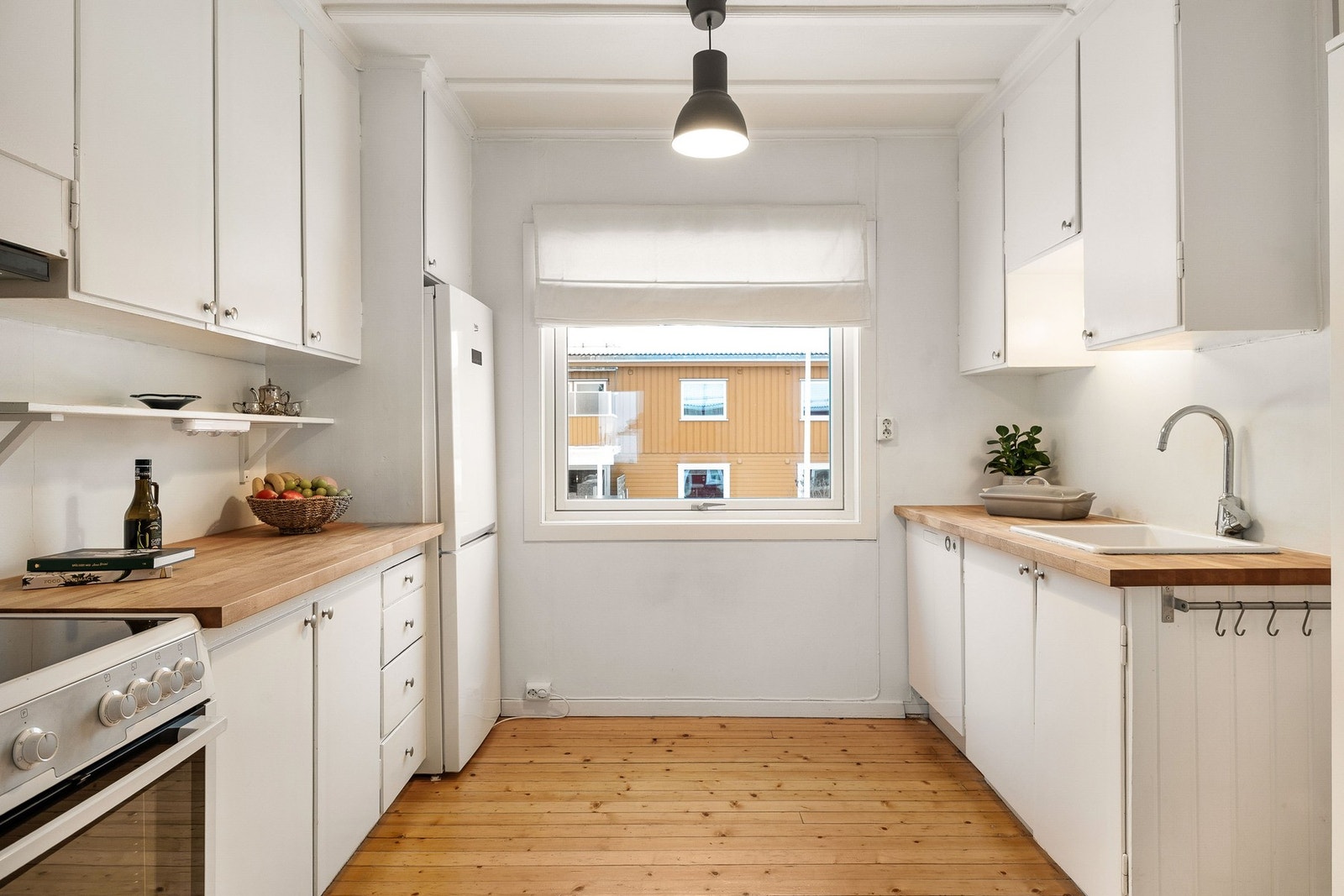 Lyst kjøkken med god benkeplass, praktisk oppbevaring og romslig arbeidsområde. Galleribilde