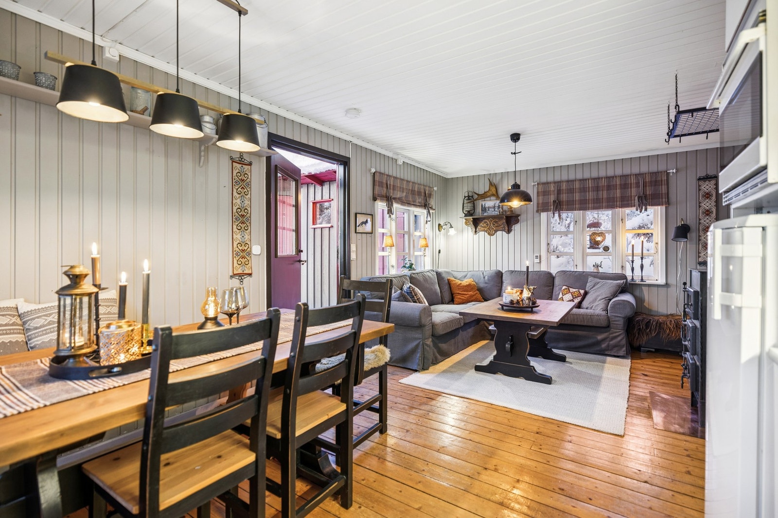 Stue og kjøkken har fine sosiale soner hvor spisestuen er plassert i forlengelse av kjøkkeninnredning og sofakrok foran peisvedovn. Galleribilde