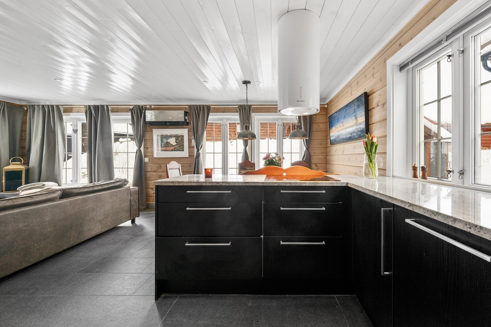 Kjøkken med platetopp ut mot spisesonen gir en sosial og god følelse Galleribilde