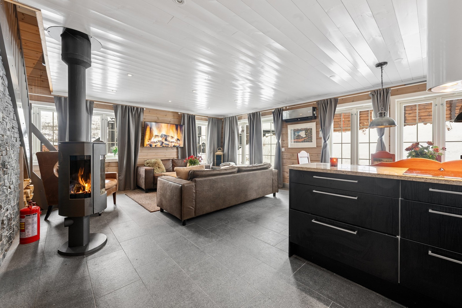 En god peis som kan ses fra både kjøkken, spis og stue Galleribilde