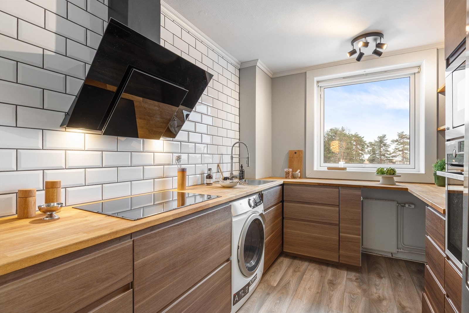 Kjøkkenet er praktisk adskilt fra stuen og fremstår som moderne og pent. Godt med skap- og benkeplass. Galleribilde