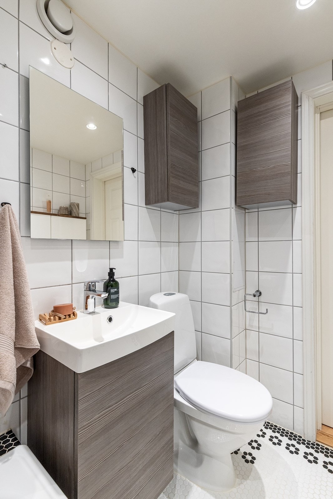 Baderommet har lyse fliser på vegg og mosaikkfliser på gulv, som gir et lyst og pent uttrykk. Galleribilde