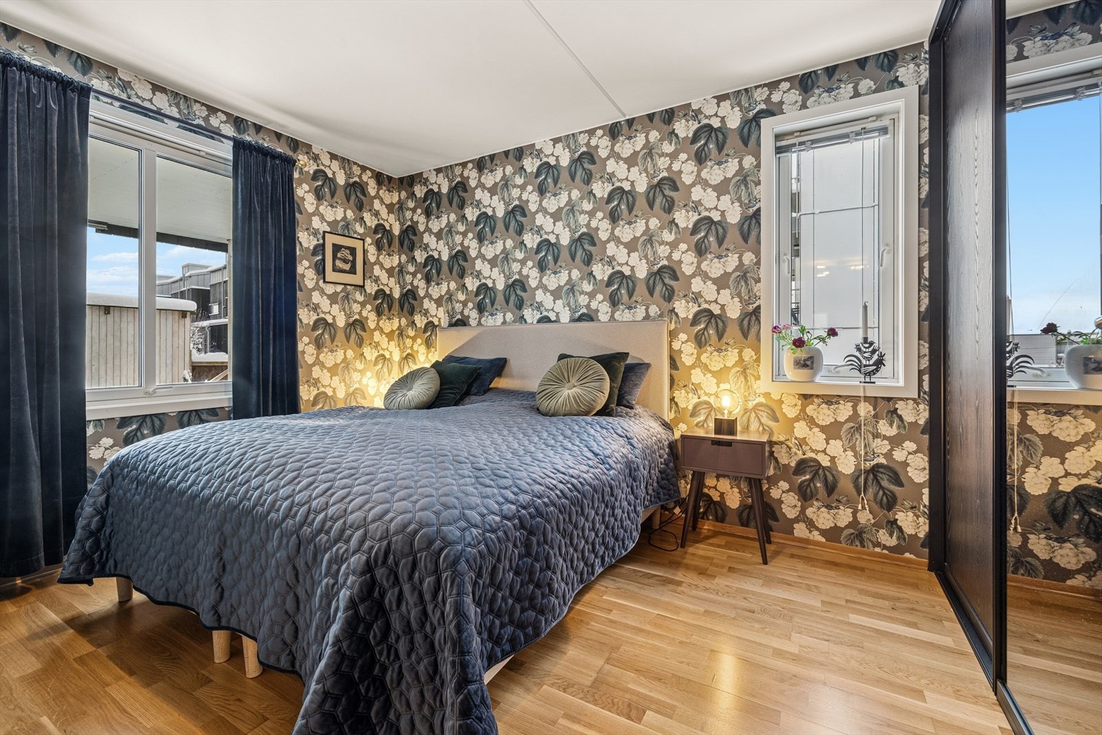 Nydelig tapetsert soverom med skyvedørsgarderobe langs den ene kortsiden av rommet. Galleribilde