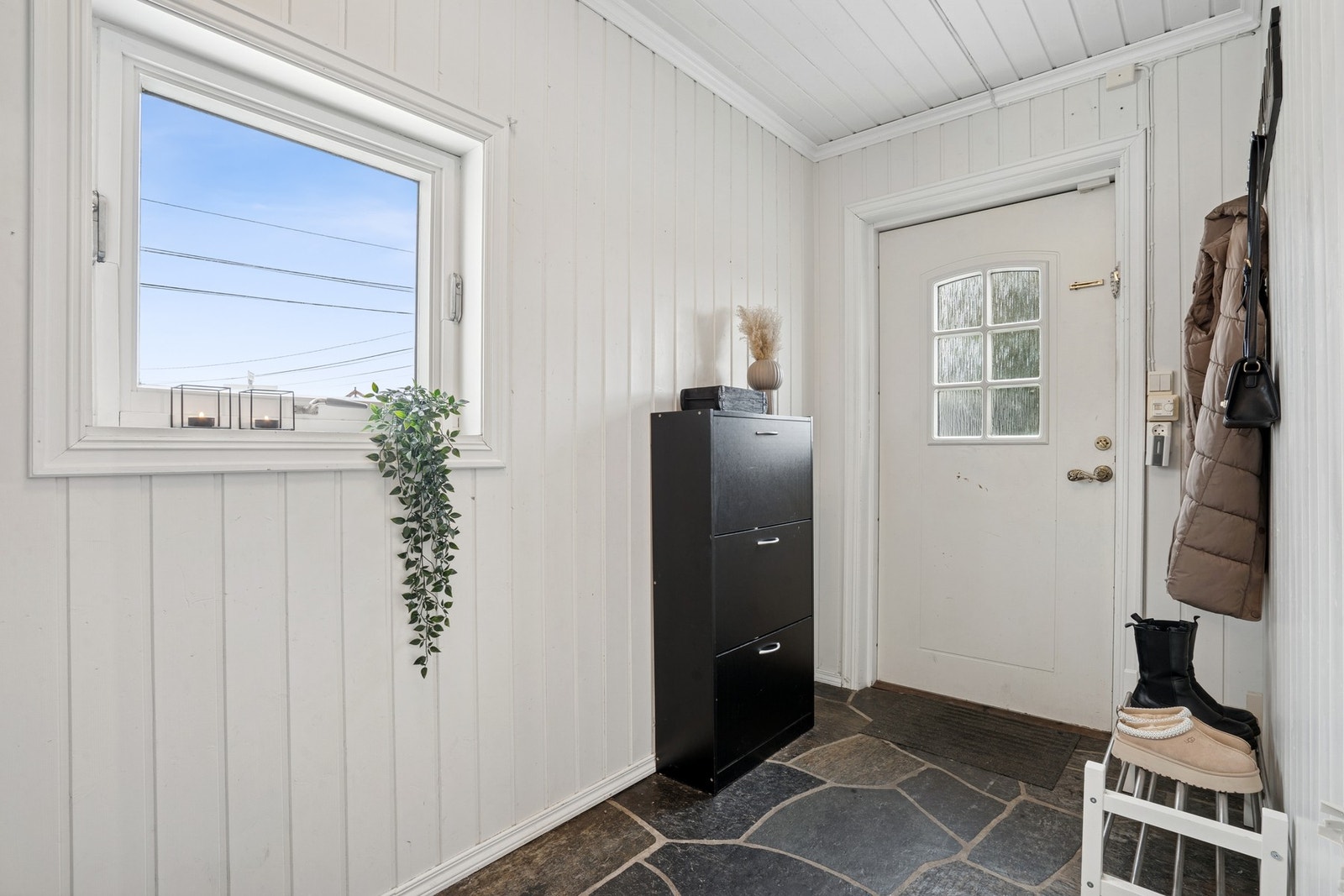 Boligen ønskes velkommen via en praktisk entré med plass til yttertøy og sko. Galleribilde