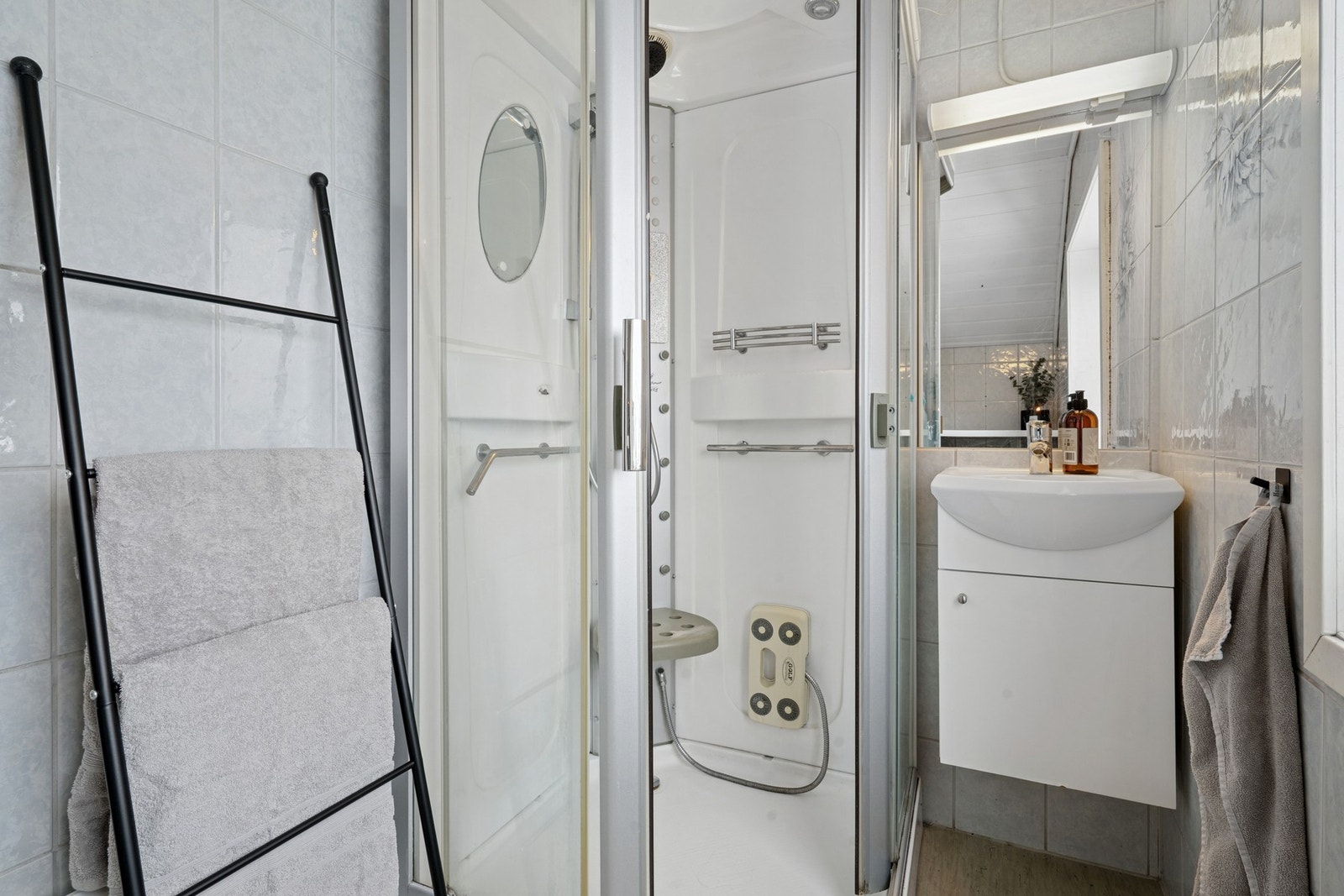 Oppe finner du et bad med dusj, baderomsinnredning og opplegg for vaskemaskin. Galleribilde