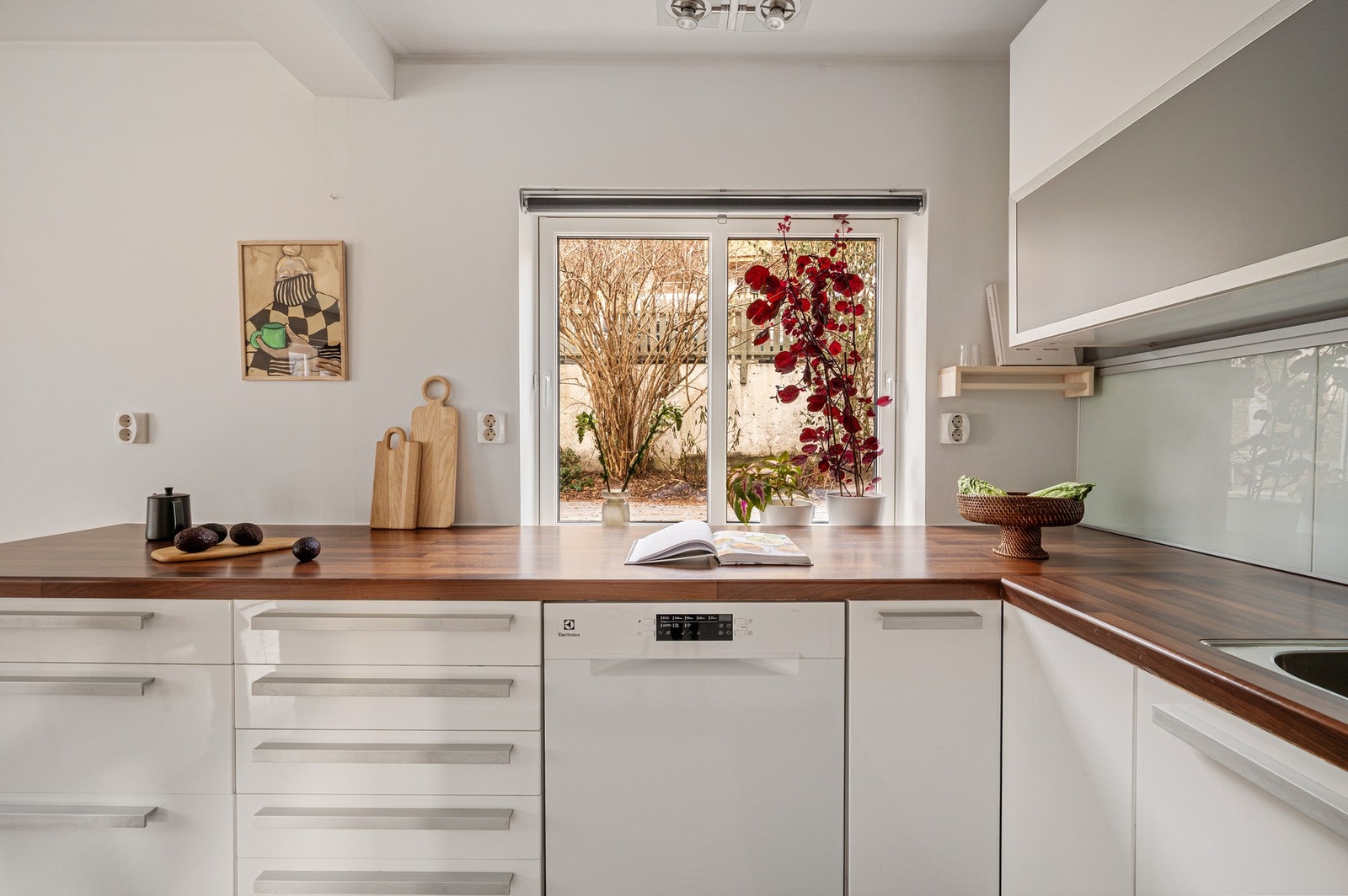 Lekkert kjøkken med slette fronter og benkeplate av laminat med nedfelt servant av stål. Galleribilde