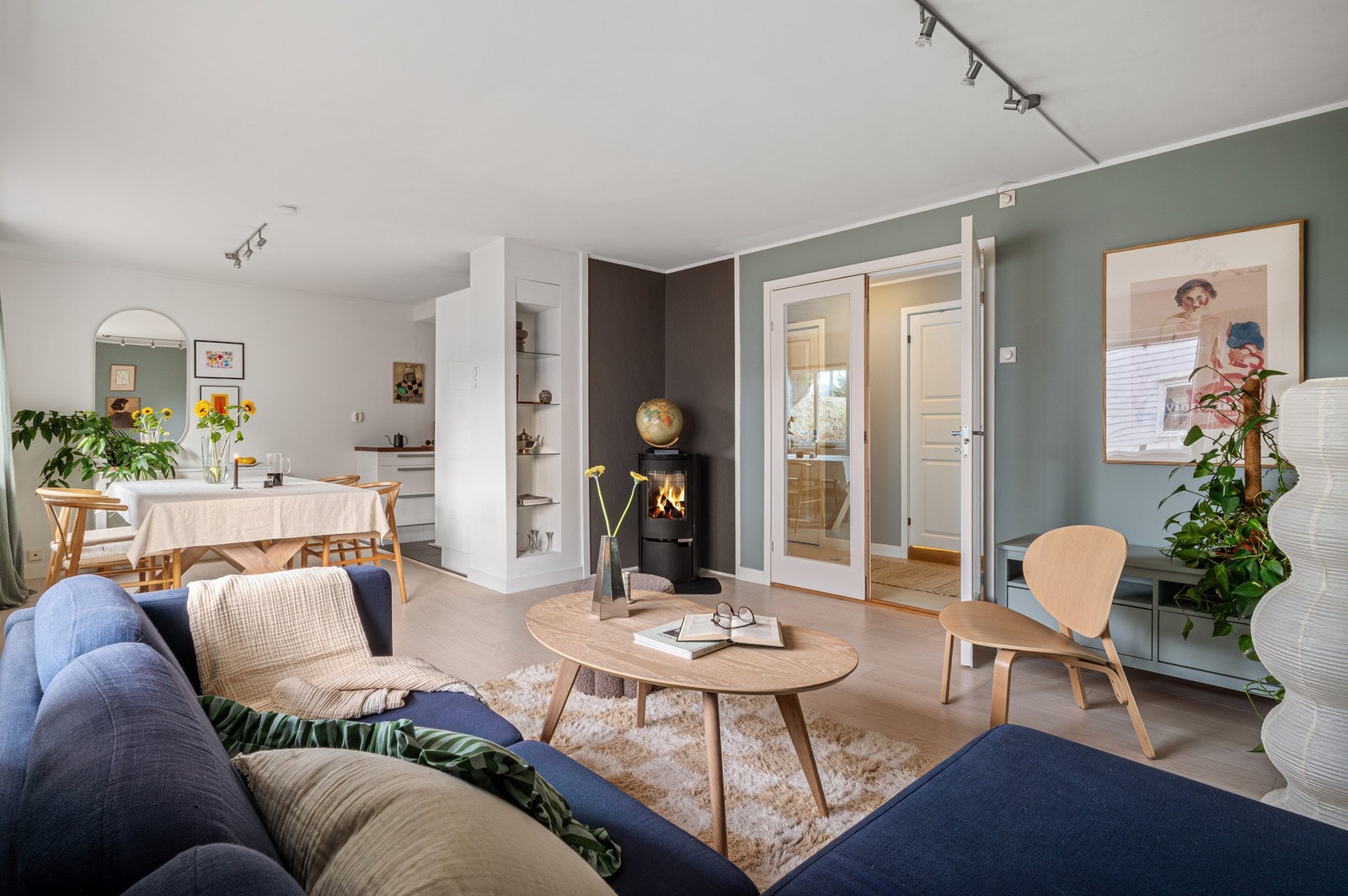 Stuen blir godt oppvarmet med en god vedovn, legg merke til flott detalj med glassdører som skiller entre og stue. Galleribilde