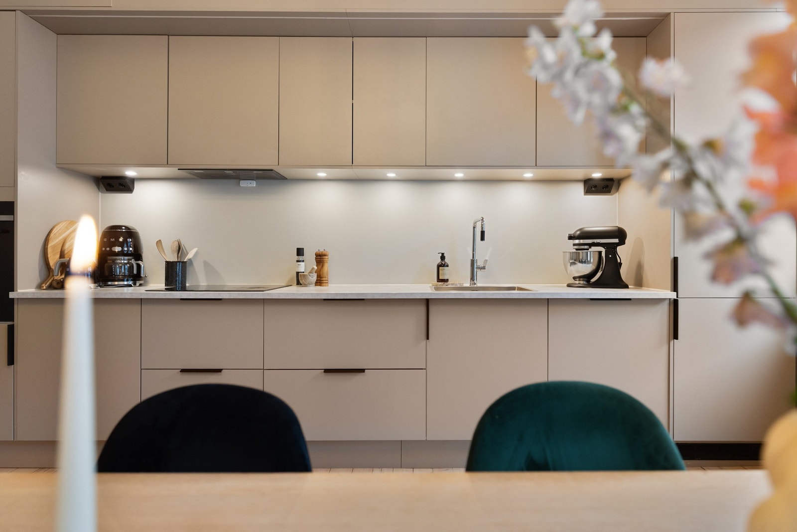 Stilrent kjøkken med beige, slette fronter og lys laminat benkeplate. Galleribilde