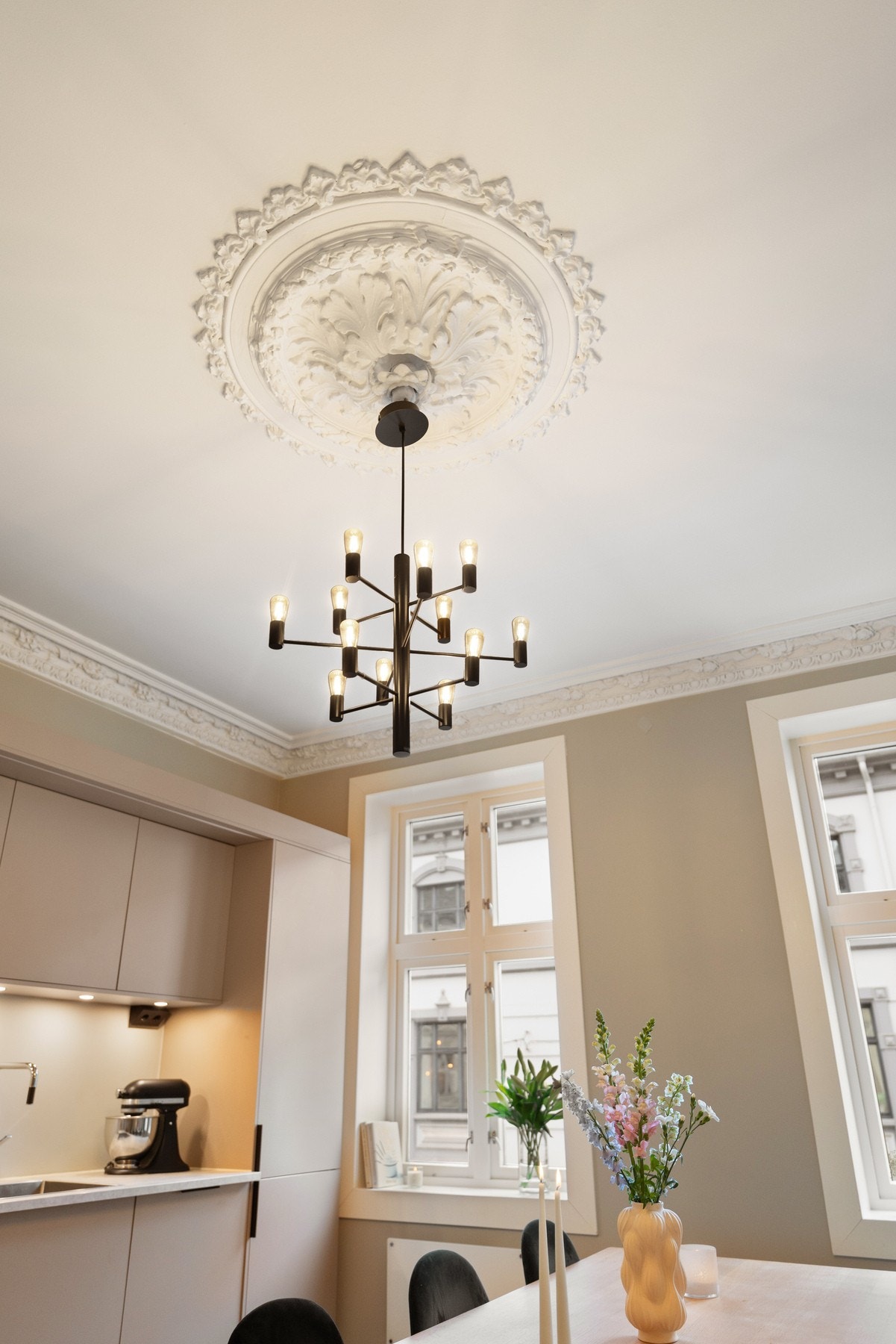 Klassiske detaljer med rosett og stukkatur i kjøkken og stue. Galleribilde