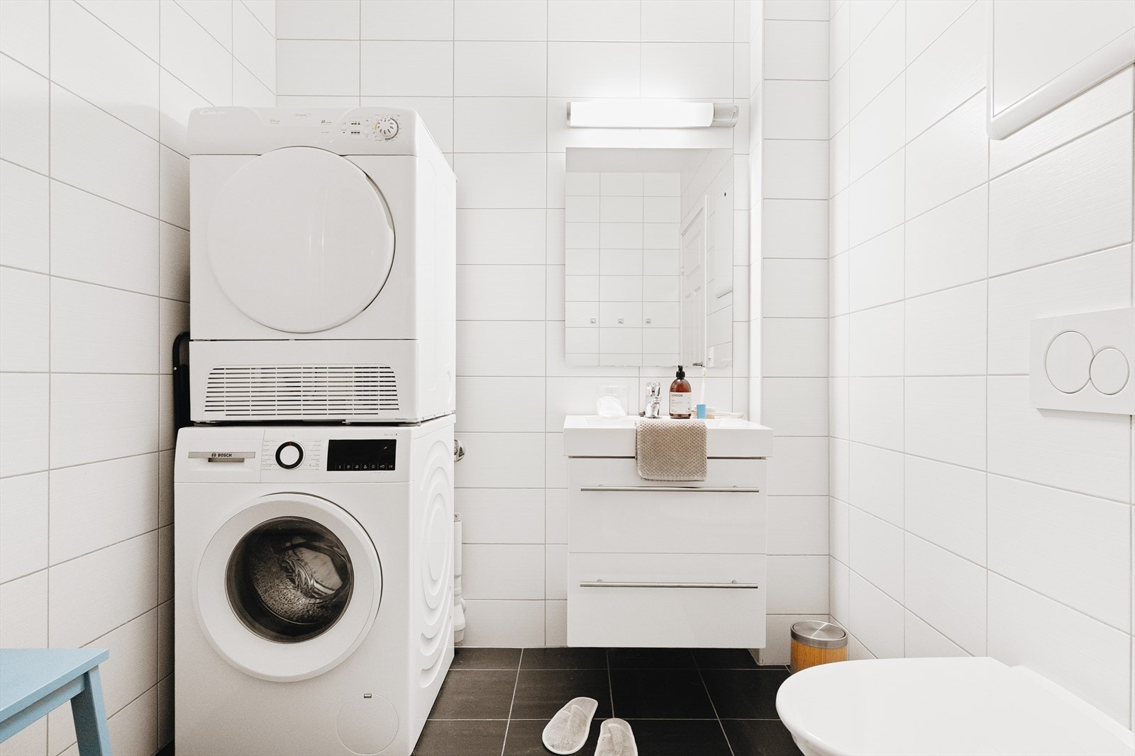 Badet er fra 2012 og inneholder baderomsmøblement med servant og speil, vegghengt toalett, dusj og opplegg for vaskemaskin Galleribilde