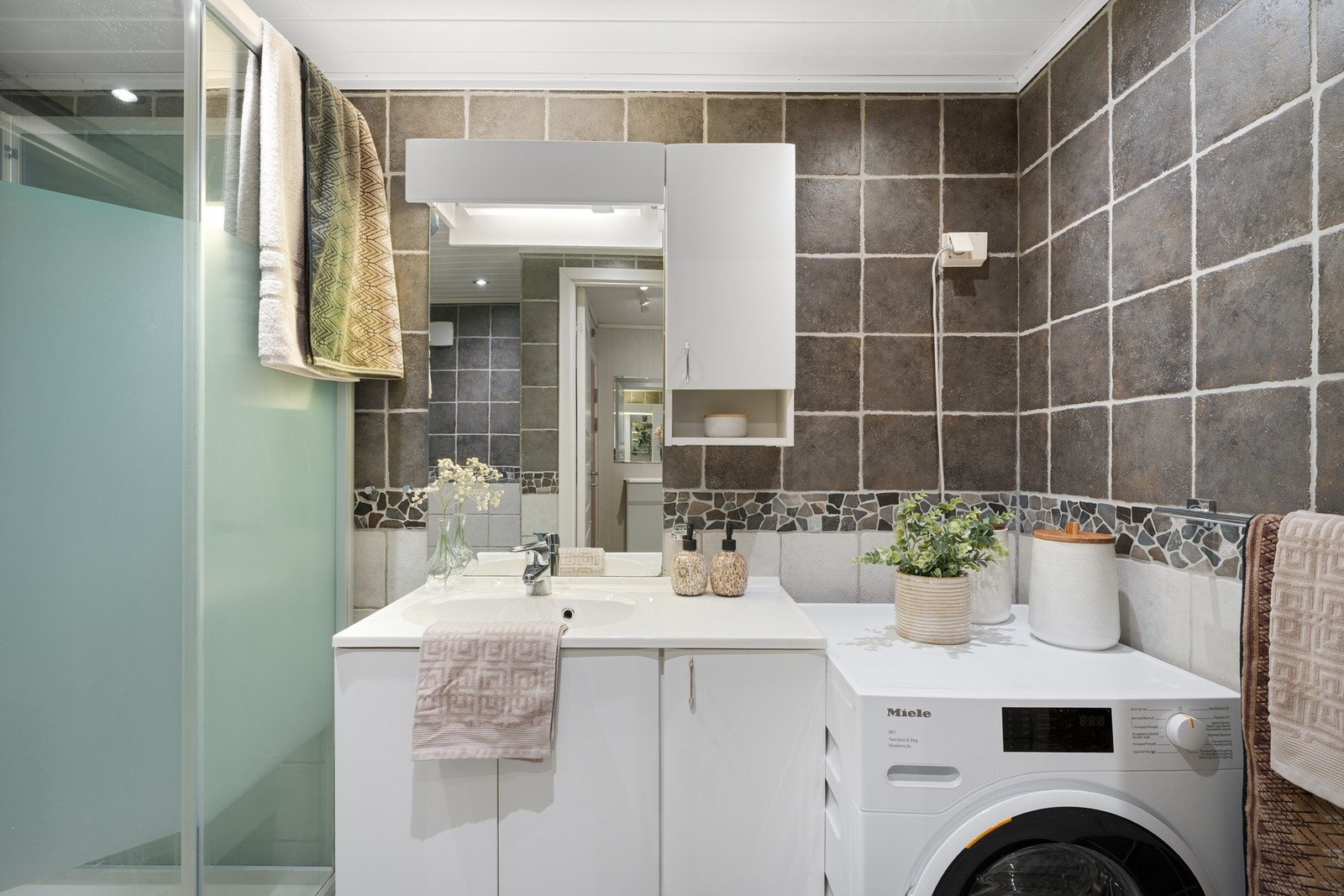 Av innredning finnes toalett, servant med underskap, overskap ved speil, opplegg for vaskemaskin og dusjkabinett. Mekanisk avtrekk. Galleribilde