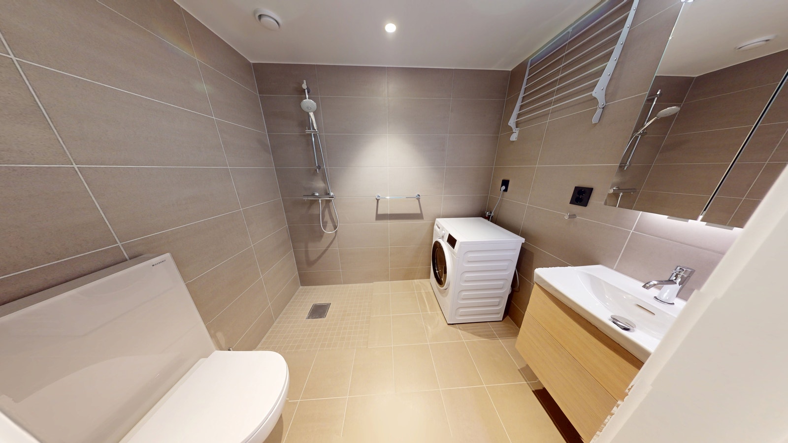 Stort fint bad med dusj, kombinert vaskemaskin med tørketrommel, speilskap, skuffer under vask. Varmekabler. Galleribilde