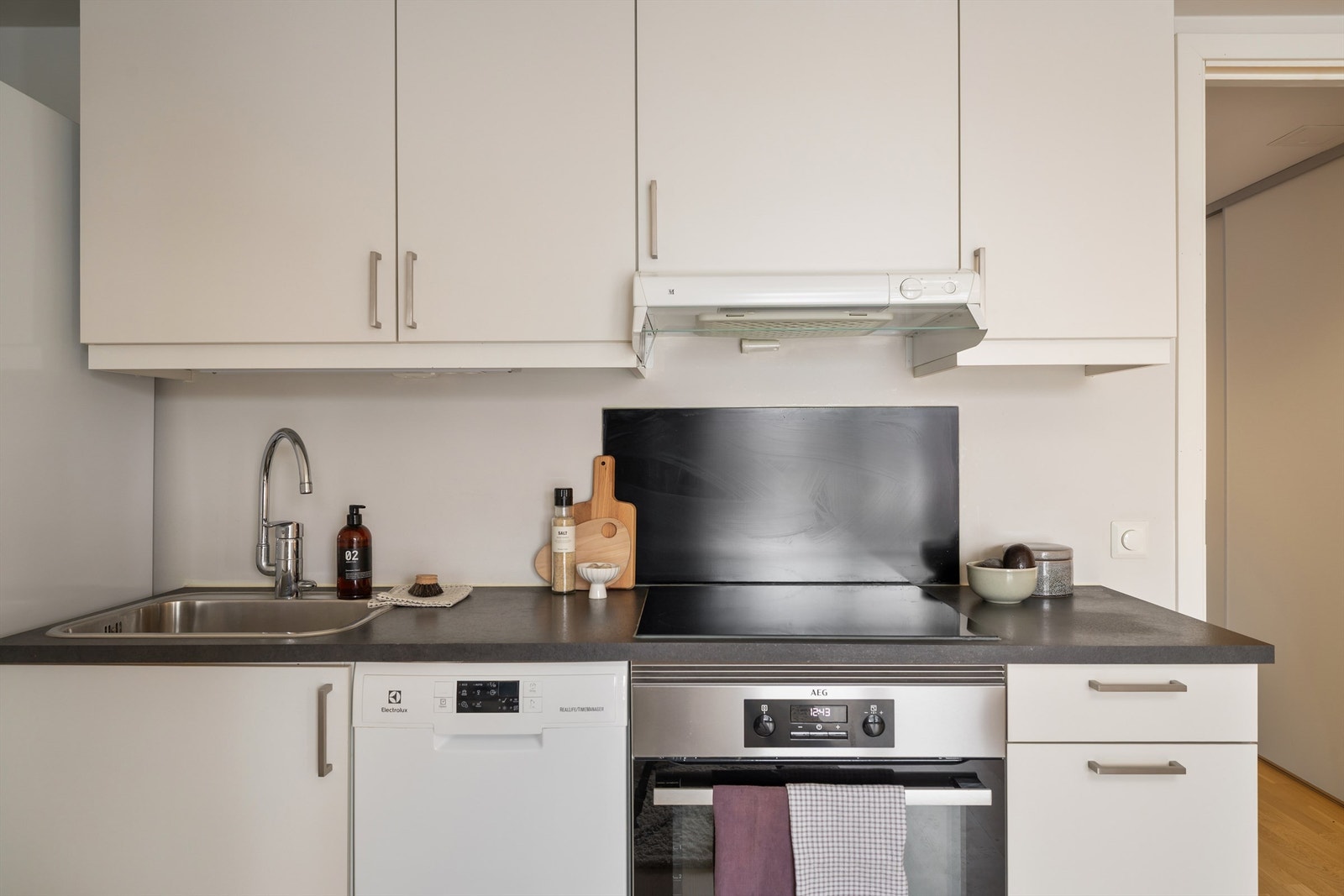 Hvitevarene medfølger og består av frittstående kjøleskap med frysedel, oppvaskmaskin, stekeovn og platetopp. Ventilator med mekanisk avtrekk i overskap. Det er montert både lekkasjestopper og komfyrvakt. Galleribilde