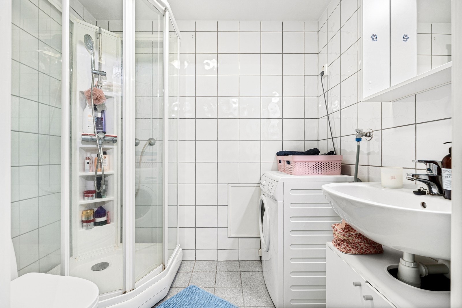 Flott, flislagt bad med varmekabler i gulv, dusjkabinett og opplegg til vaskemaskin Galleribilde