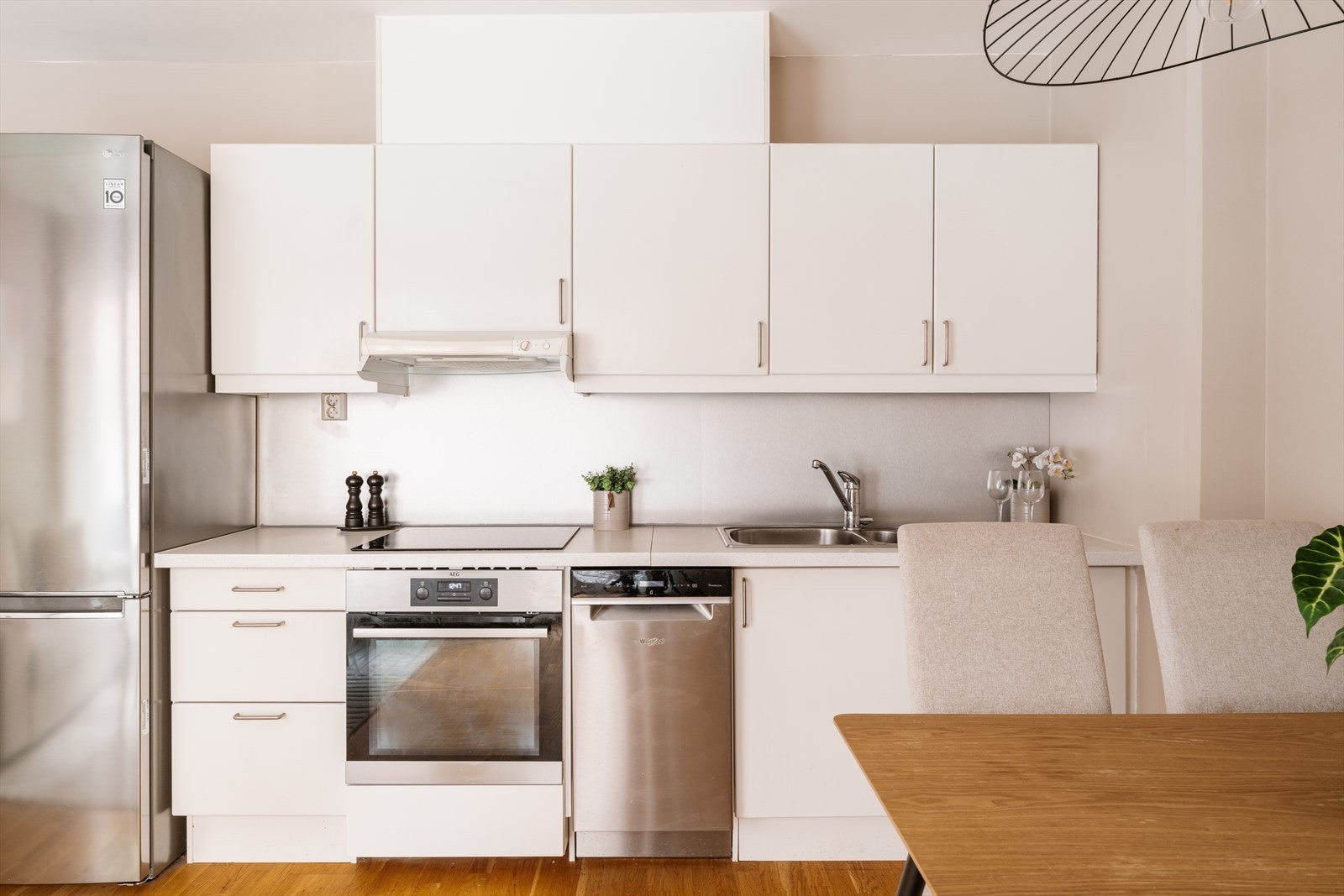 Moderne kjøkkeninnredning med glatte fronter og laminat benkeplate. Galleribilde