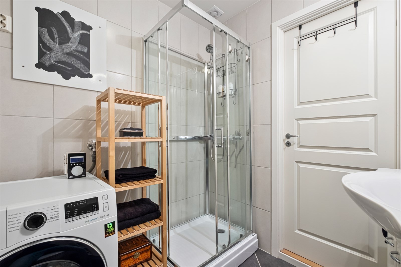 Badet er utstyrt med servant, dusjkabinett og opplegg for vaskemaskin Galleribilde