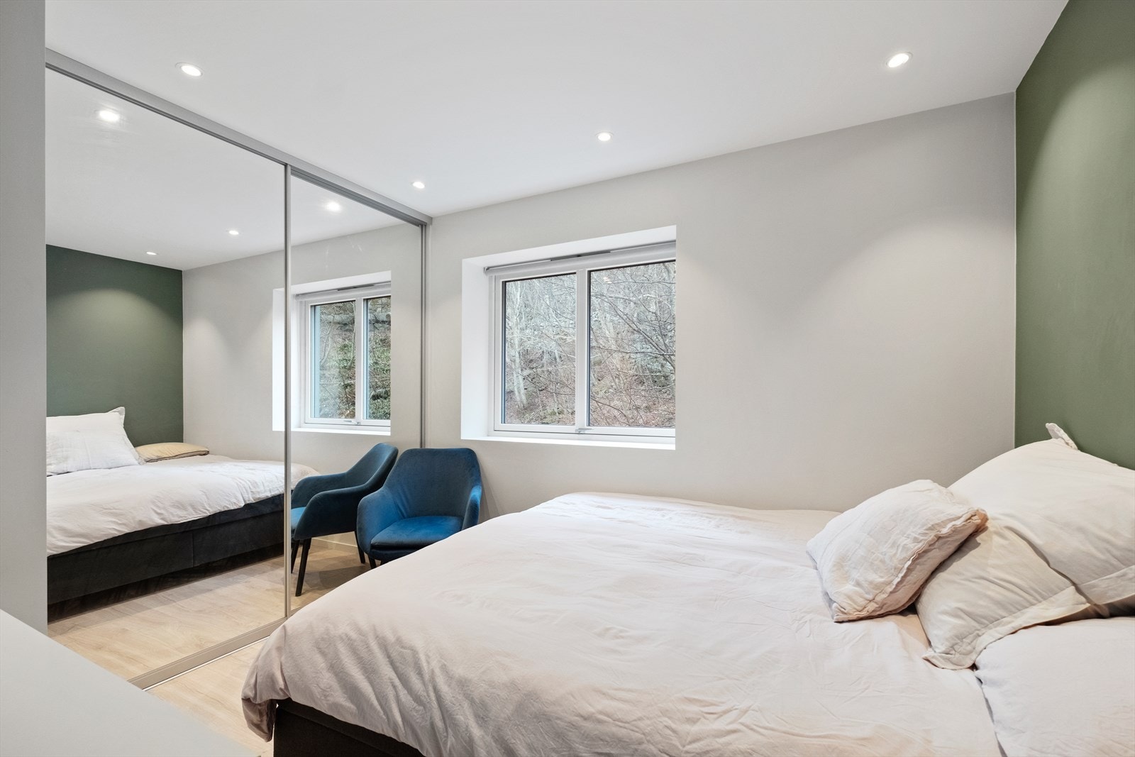 Lyst og romslig soverom med stort integrert garderobeskap Galleribilde