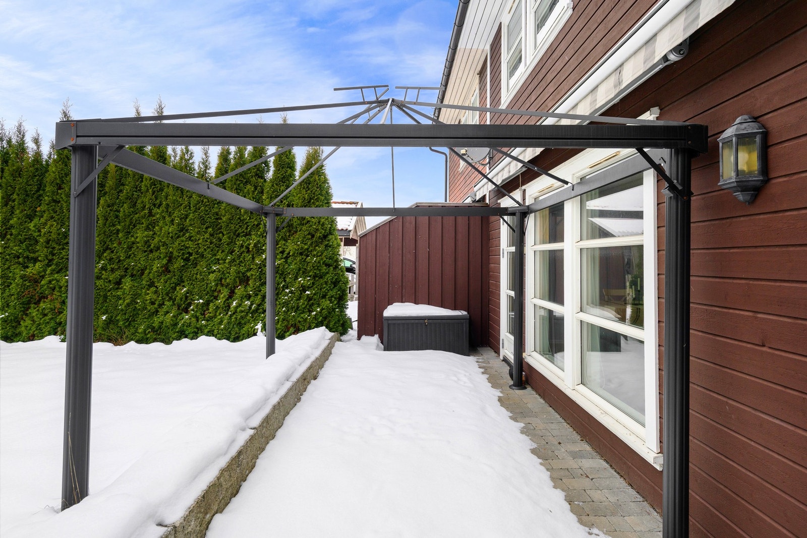 Det er solrik, steinlagt uteplass med utgang fra stuen. Galleribilde