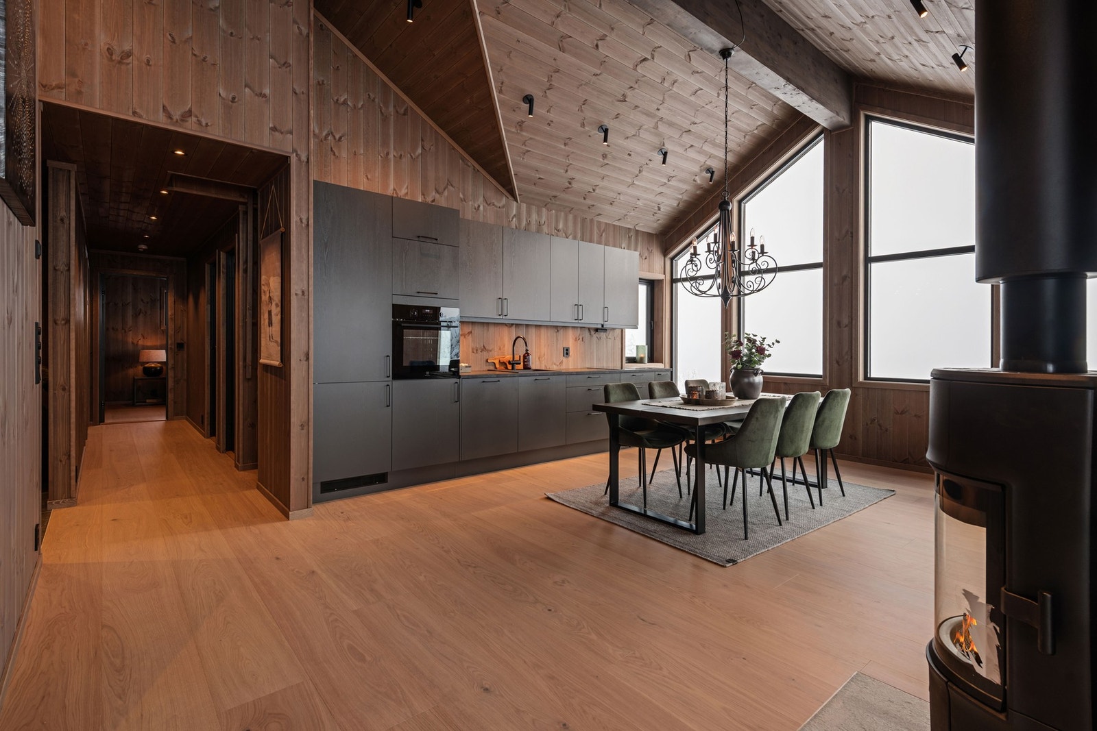 Stilrent kjøkken med over- og underskap, mørke fronter og integrerte hvitevarer. Galleribilde