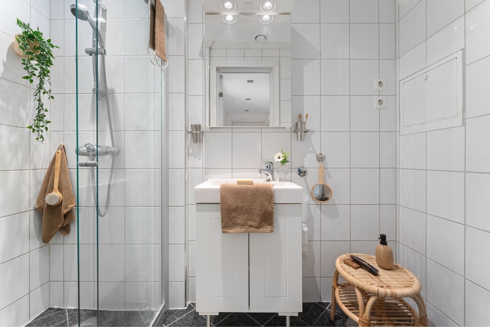 Badet er utstyrt med skyvedør i dusjen, toalett og baderomsinnredning med heldekkende servant, samt belyst speil Galleribilde