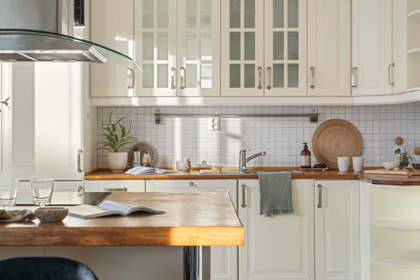 Kjøkkenet har hvit innredning med en oljet benkeplate med kjøkkenbeslag Galleribilde