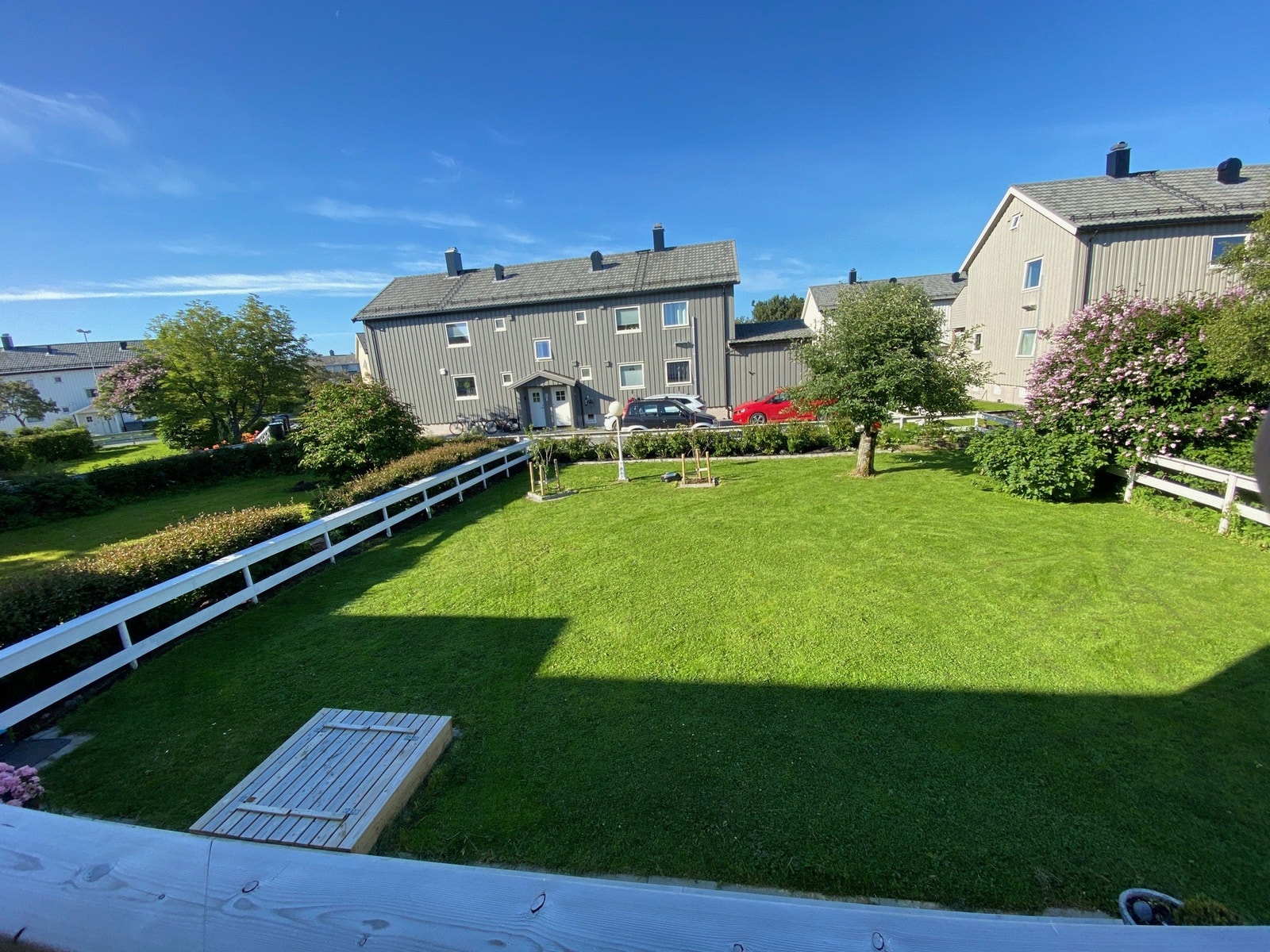 Koselig inngjerdet hage med medfølgende robotklipper. Praktisk felles utebod for oppbevaring av hageredskaper mm. Galleribilde