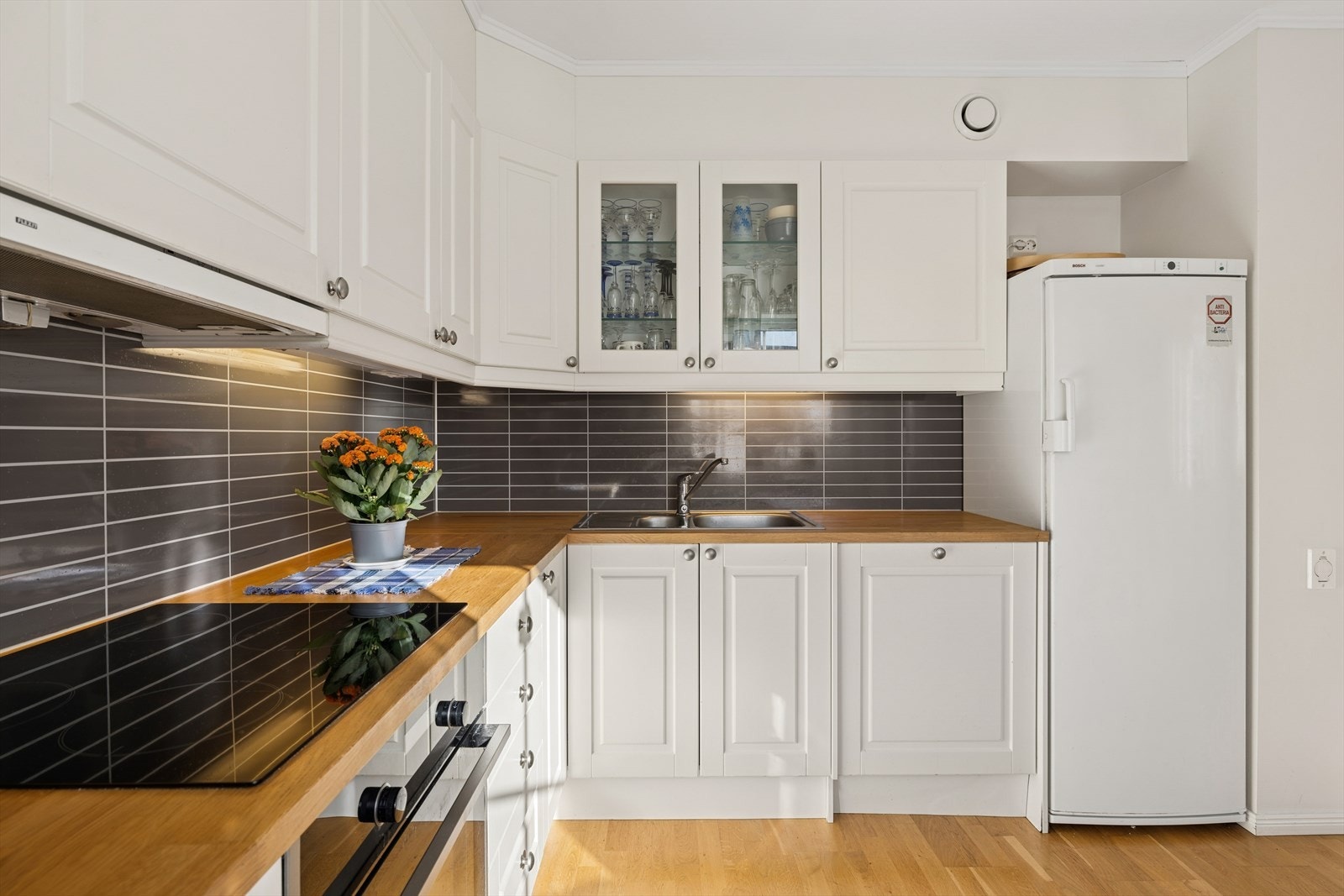 Lyst og funksjonelt kjøkken i åpen løsning mot spisestue - en sosial og praktisk planløsning Galleribilde