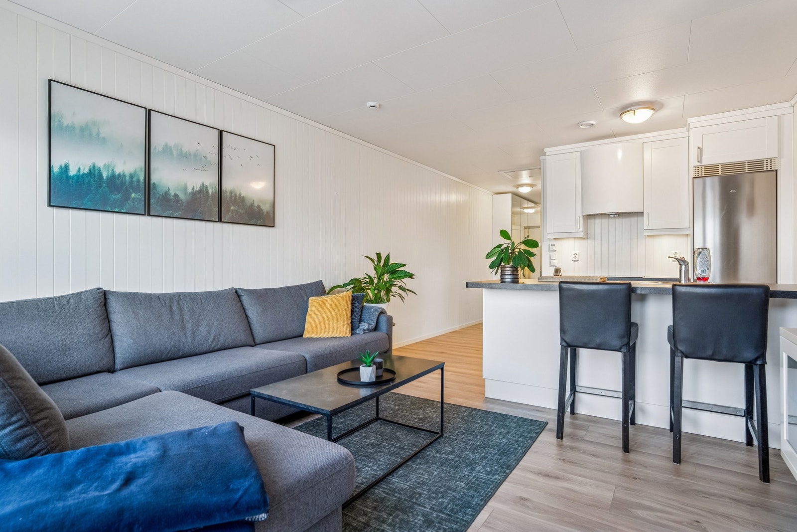 Stue og kjøkken avdelt med kjøkkenøy med barløsning Galleribilde