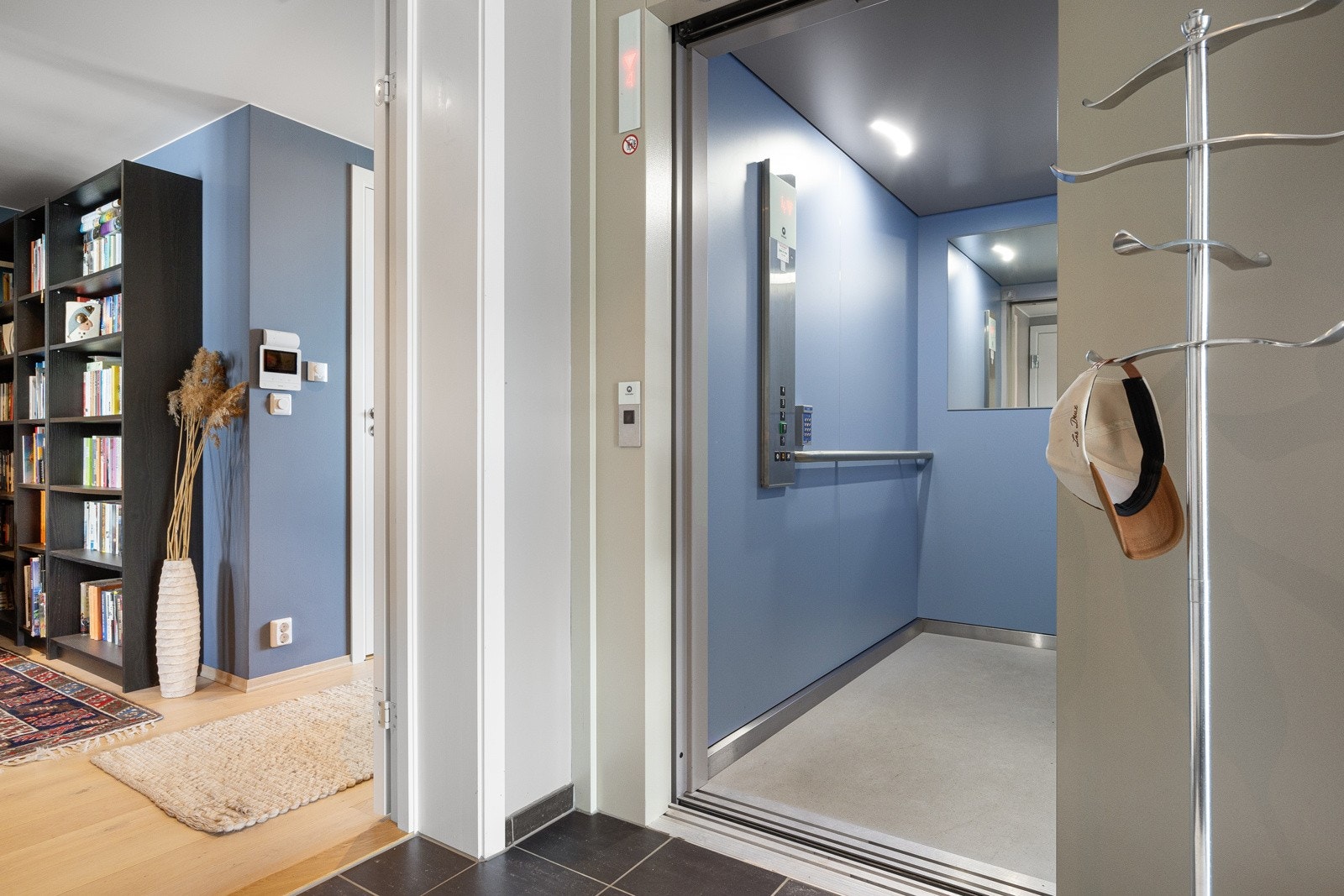 Med privat kode tar heisen deg diskret og direkte opp til leiligheten, og åpner seg rett inn i en romslig og stilren entré med god plass til oppbevaring av yttertøy Galleribilde