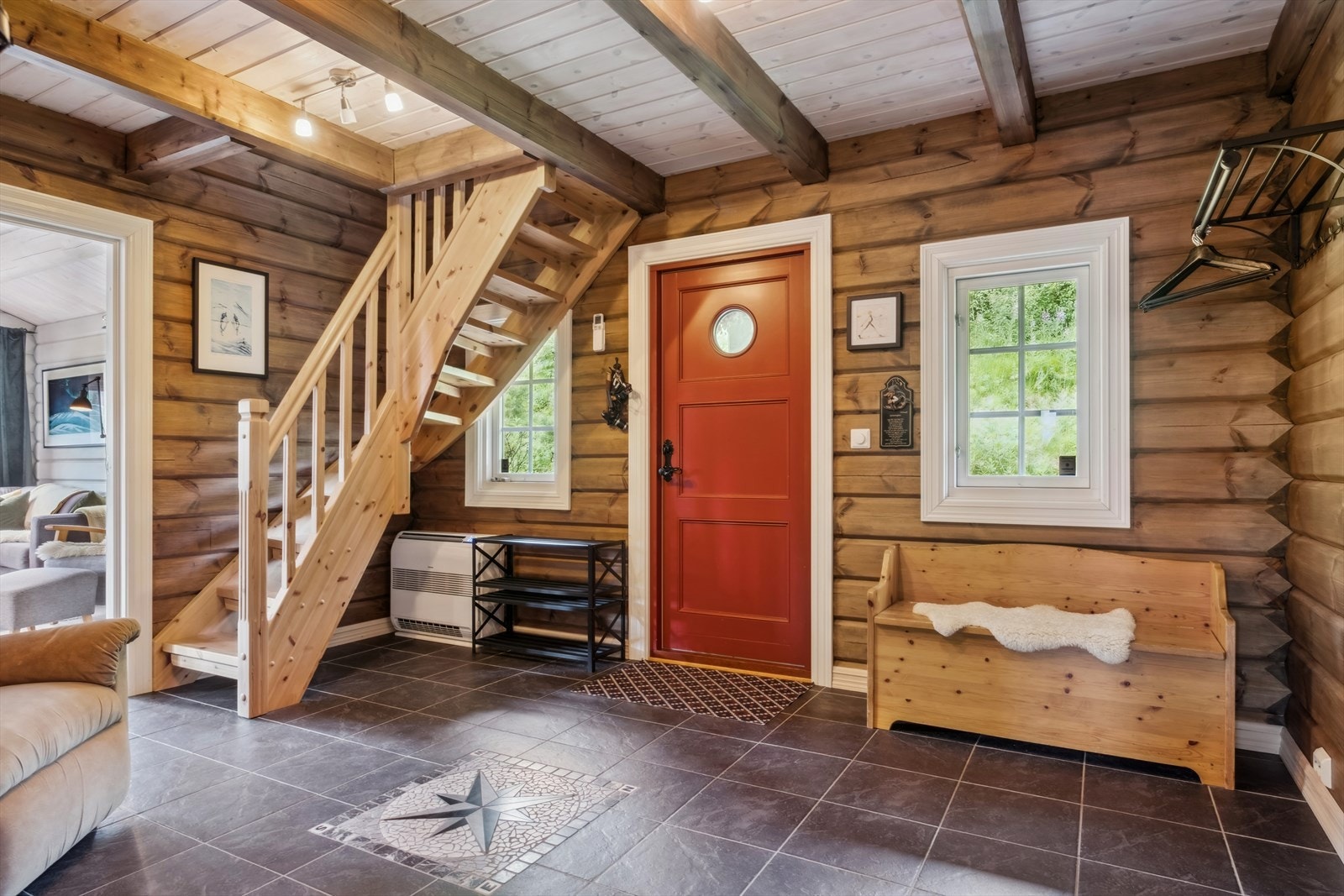 Romslig hall med flisbelagt gulv med varmekabler og varmepumpe. Galleribilde