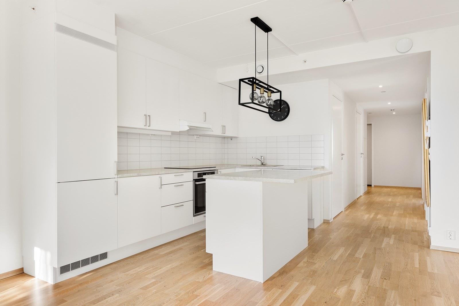 Kjøkkenet har en tidløs og stilren innredning med lakkerte, slette fronter og laminat benkeplate. Galleribilde