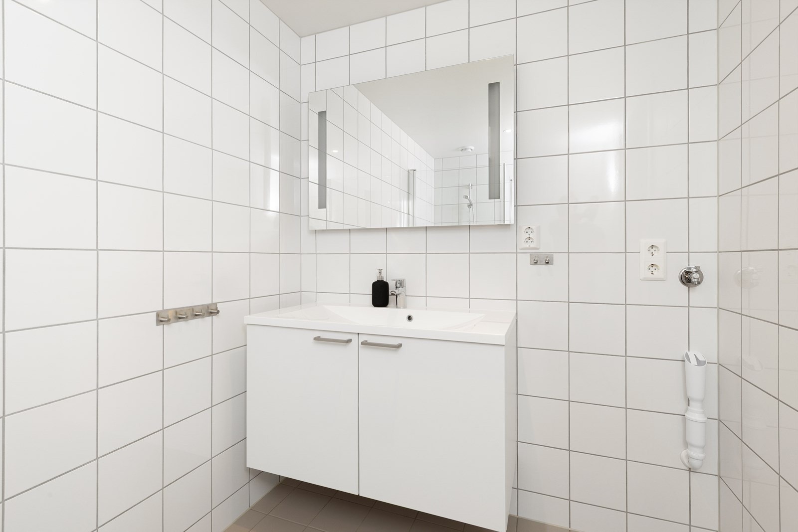 Rommet er utstyrt med innredning med servant, speil med integrert belysning, vegghengt toalett og dusjhjørne med glassvegger, samt at det er opplegg for vaskemaskin. Galleribilde